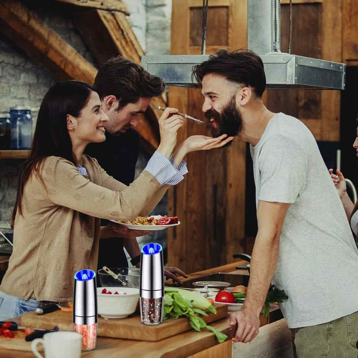 Menschen in der Küche, einer füttert den anderen, Salz- und Pfeffermühlen.