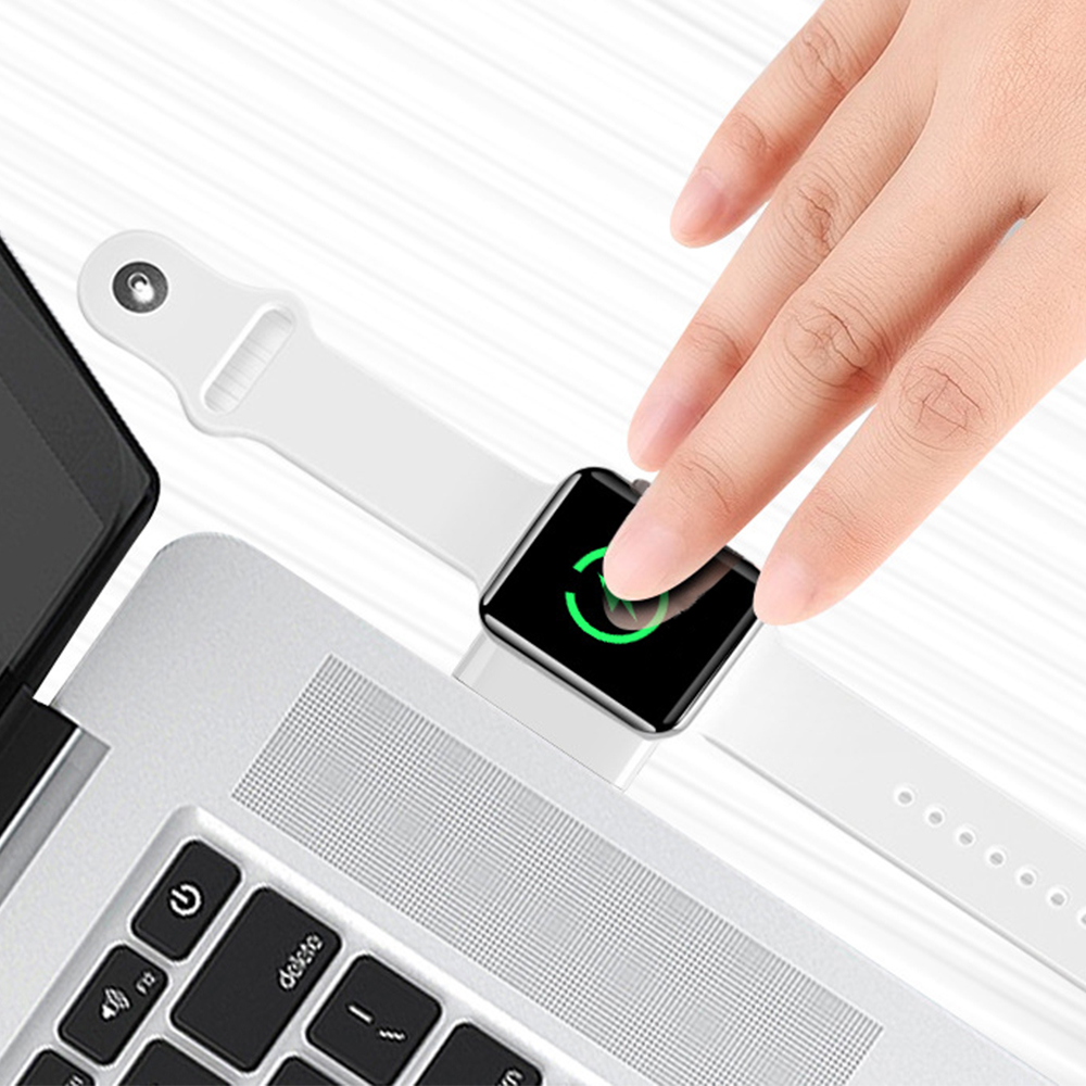Eine Hand berührt eine Smartwatch an einem weißen Armband, in der Nähe einer Laptop-Tastatur.