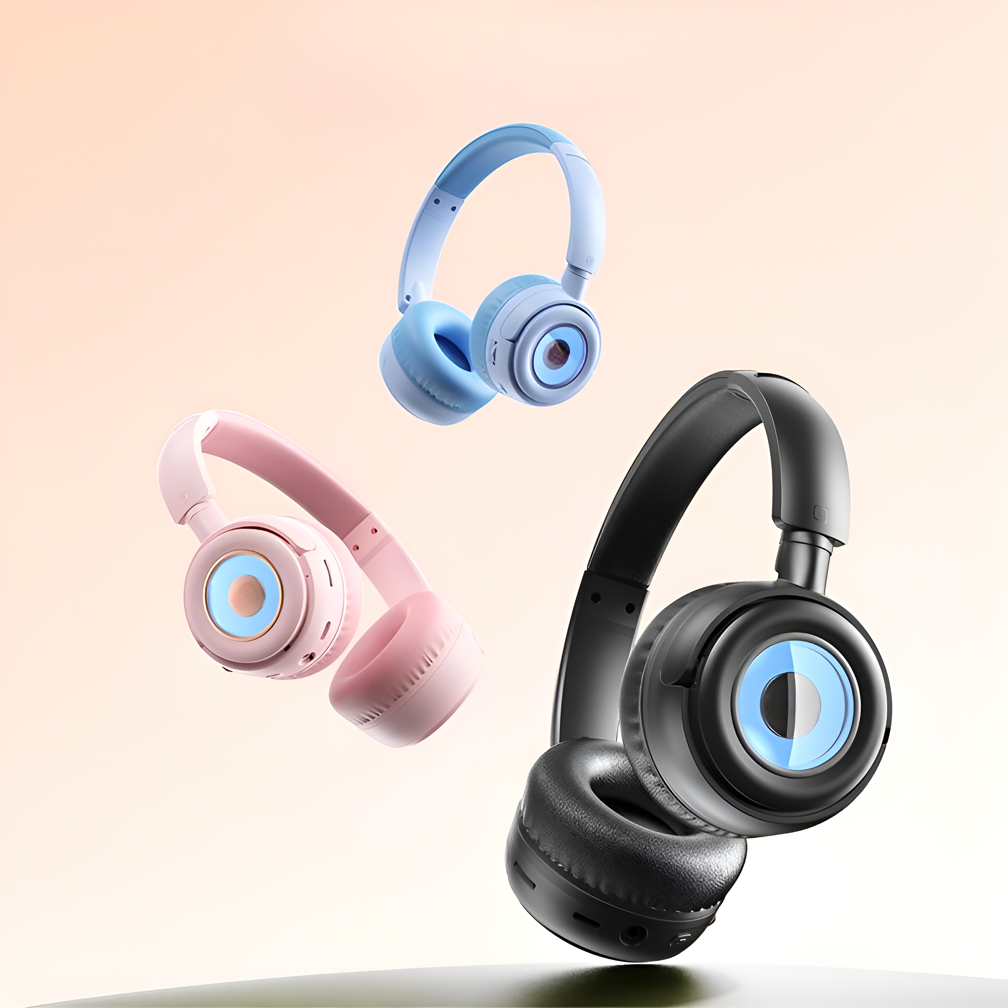Drei kabellose Kopfhörer. Blau, rosa und schwarz. Alle haben ein kreisförmiges Design auf den Ohrmuscheln.