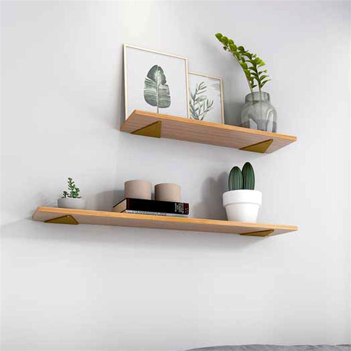 Zwei Holzregale mit Pflanzen und Dekoration sind an einer weißen Wand befestigt. Goldene Halterungen stützen die Regale.