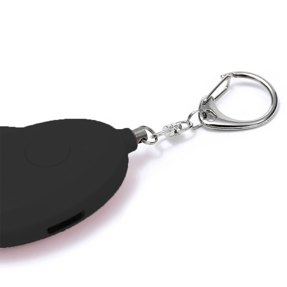 Ein schwarzer Schlüsselanhänger mit einem silbernen Ring und einem kleinen schwarzen runden Gerät.