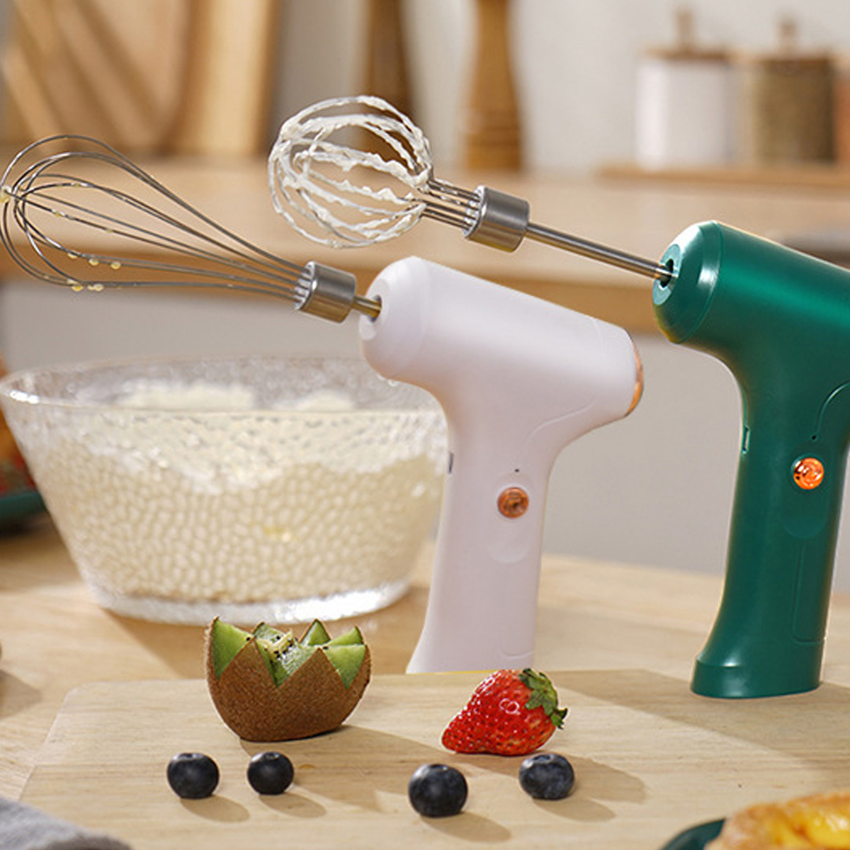 Zwei Mixer, Früchte und eine Schüssel mit Sahne auf einem Holztisch.