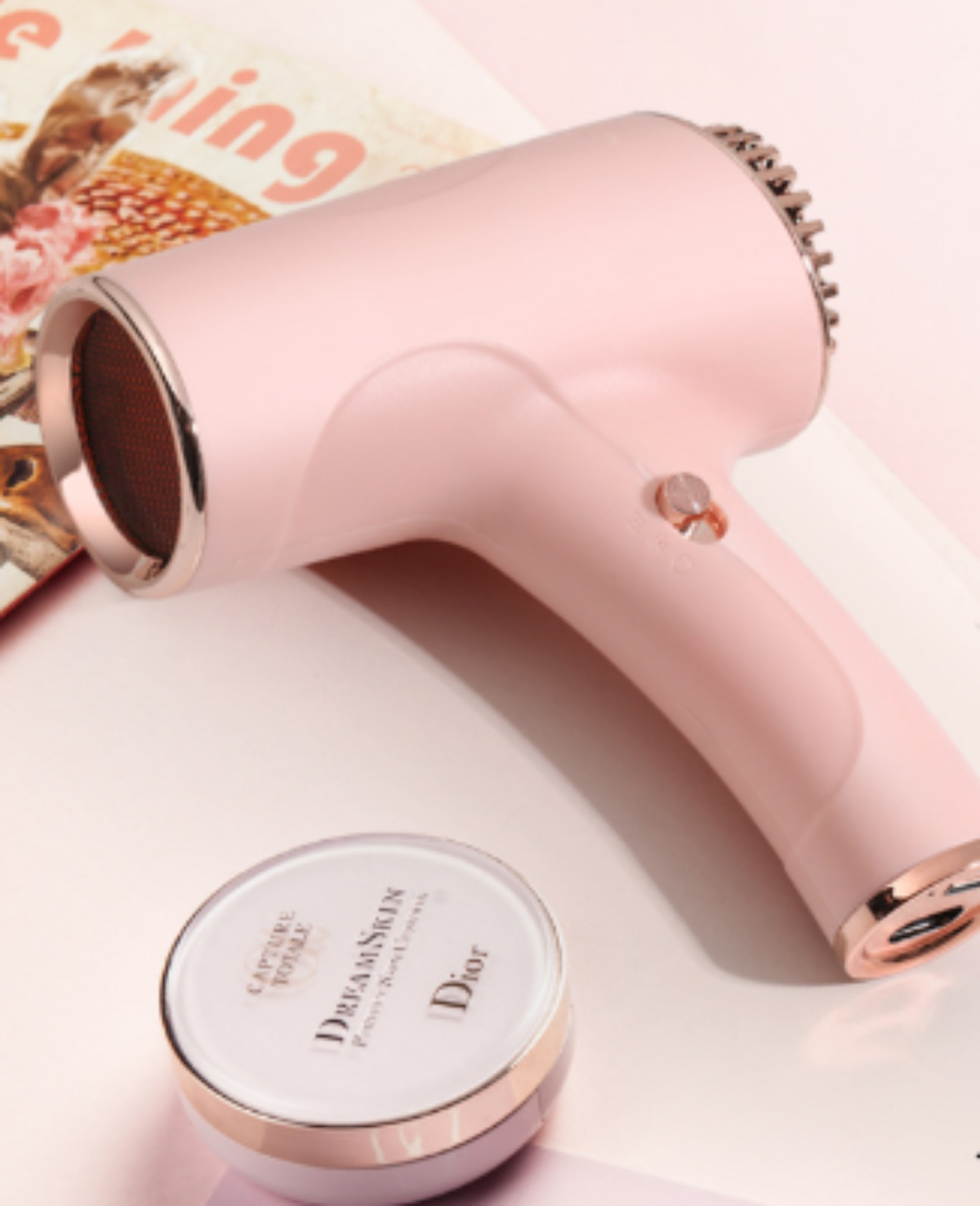 Ein pinker Haartrockner mit einem Kosmetikcremebehälter auf einem Hintergrund mit rosa Farbe.