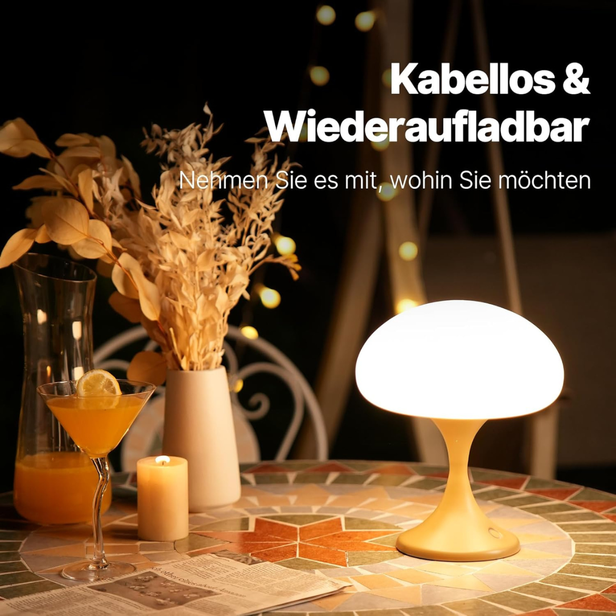 Eine beleuchtete Lampe auf einem Tisch, mit einem Cocktail und einer Kerze. Die Szene ist draußen bei Nacht.