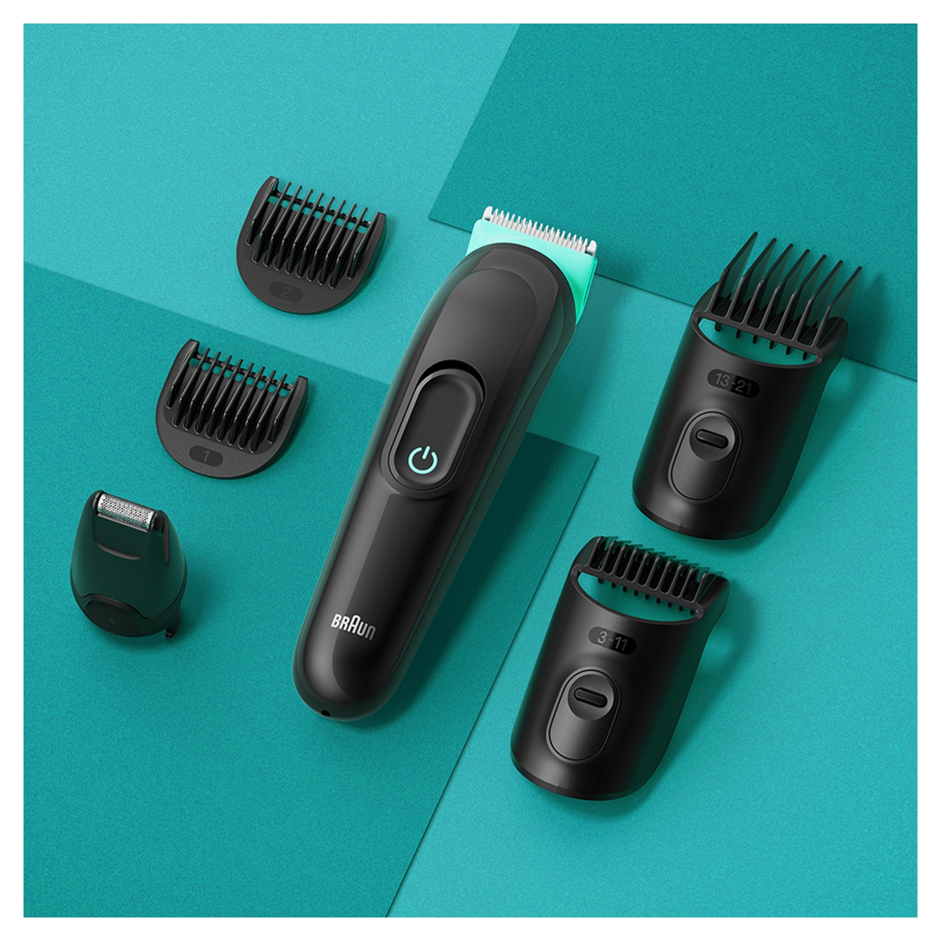 Una recortadora de barba negra con varios accesorios sobre una superficie verde azulado. Botón de encendido.