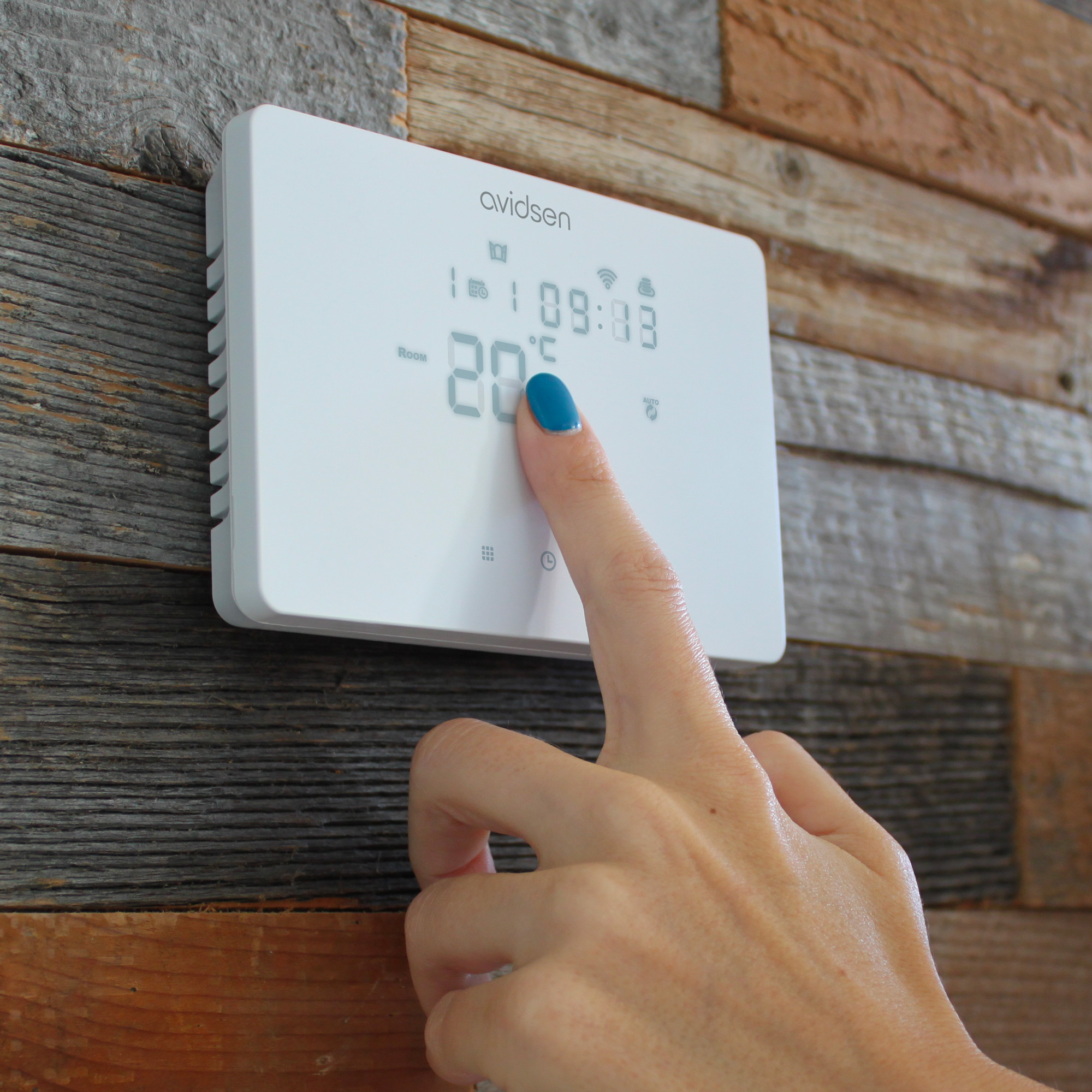 Termostato bianco con display digitale che mostra ora e temperatura. Una mano tocca lo schermo.