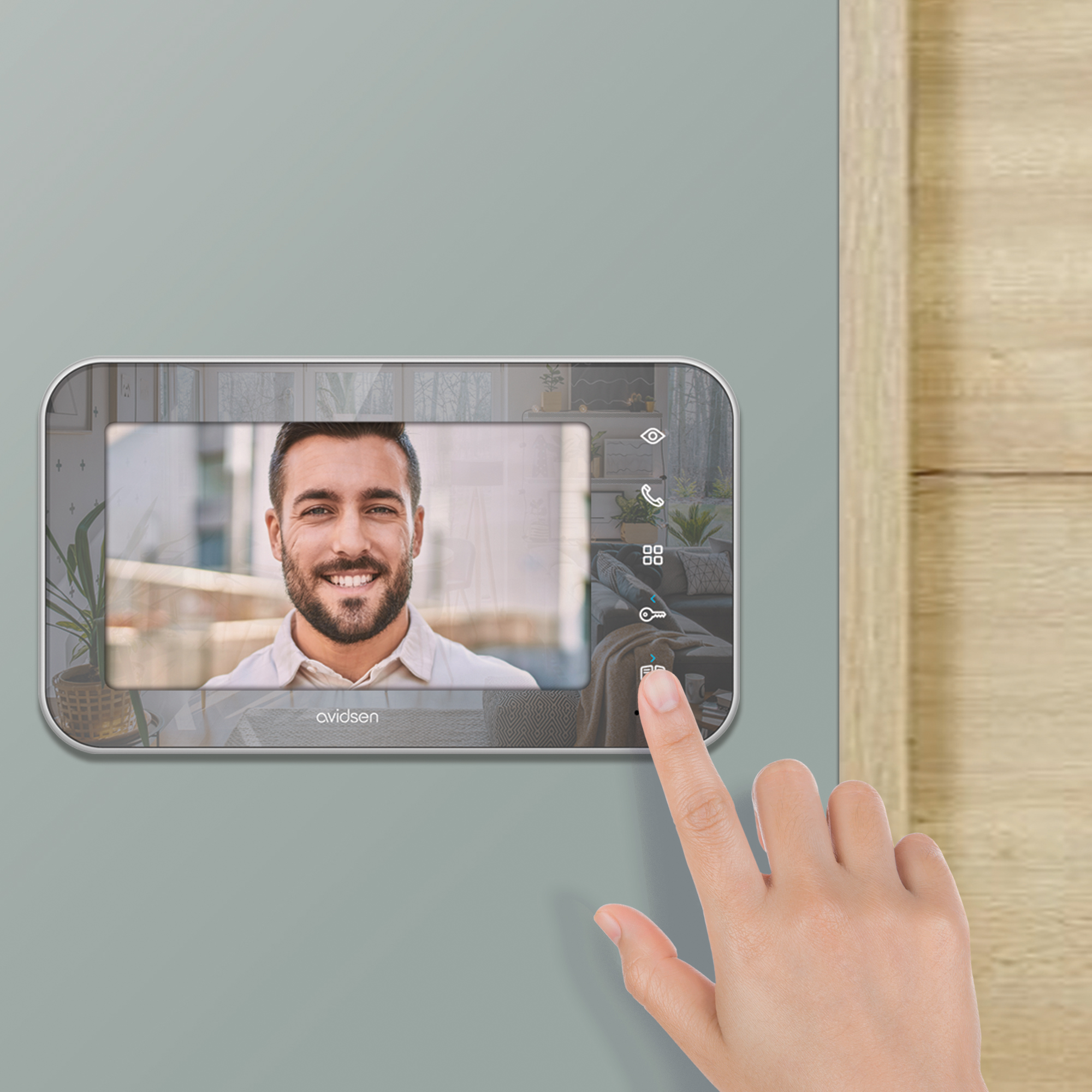 Una persona presiona un botón en una pantalla de video portero. La pantalla muestra a un hombre sonriendo.