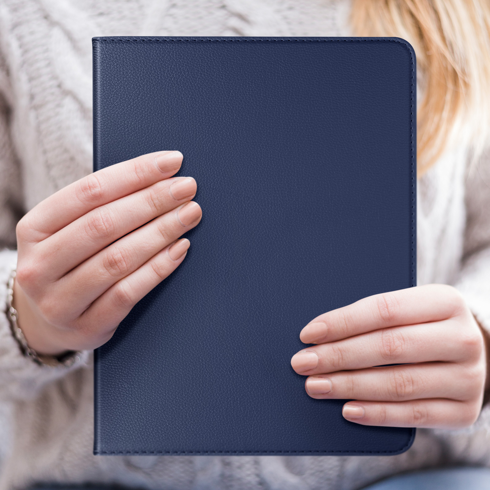 Donna che tiene una custodia blu per tablet, con sfondo neutro.