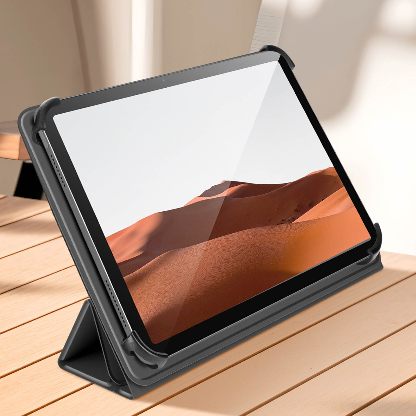 Tablet in una custodia nera, appoggiato su una superficie di legno. Un paesaggio desertico sullo schermo.