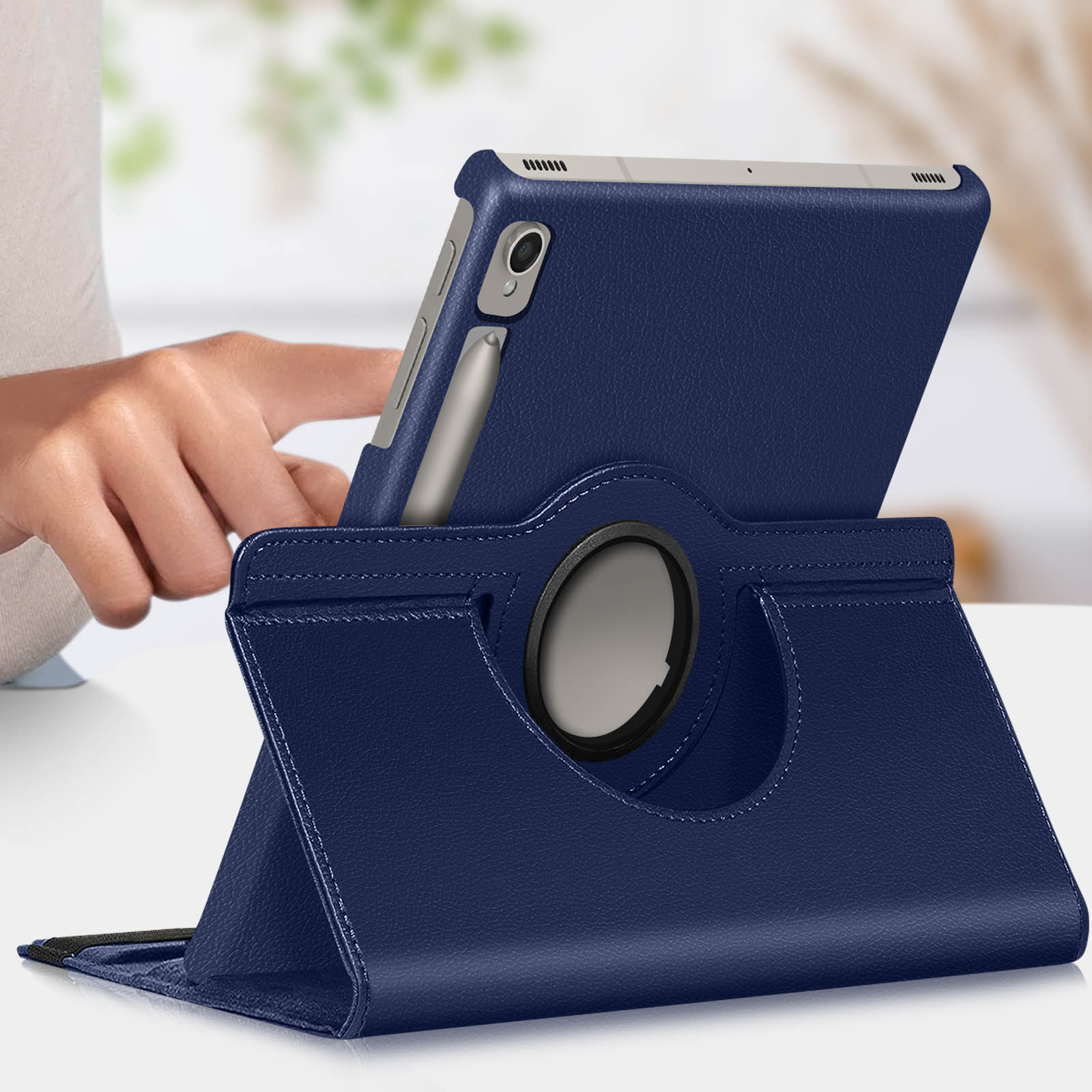 Tablet blu in un supporto. Mano e penna presenti.