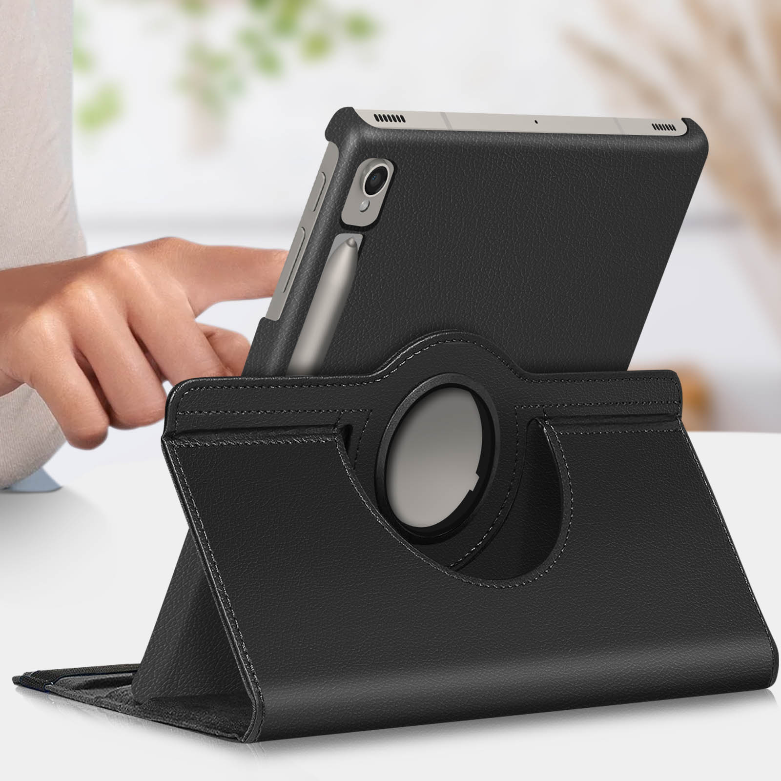 Tablet nero in custodia di pelle nera con supporto rotante. Una mano lo tiene.