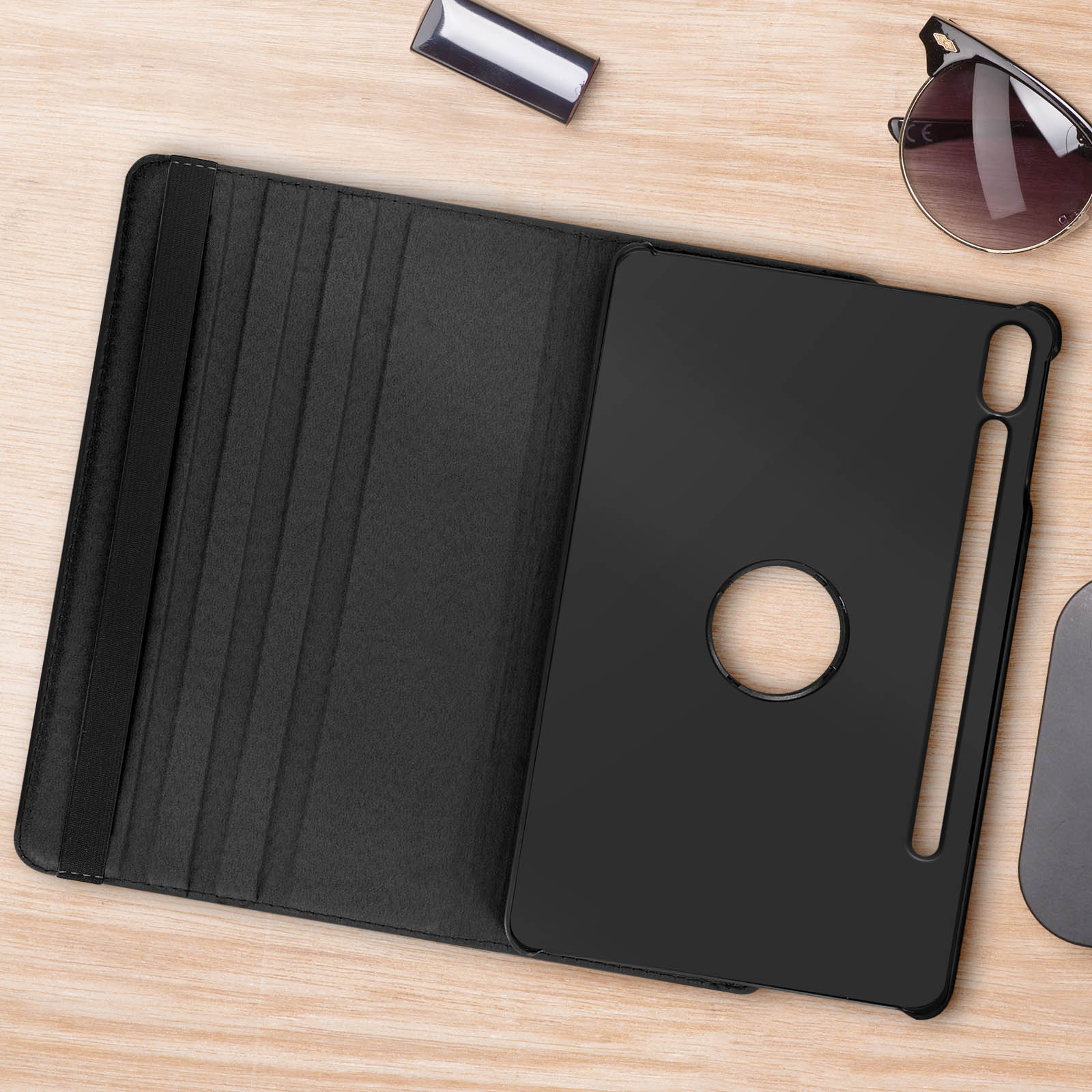 Custodia per tablet nera aperta, con interno nero e alloggiamento per penna. Su superficie in legno.