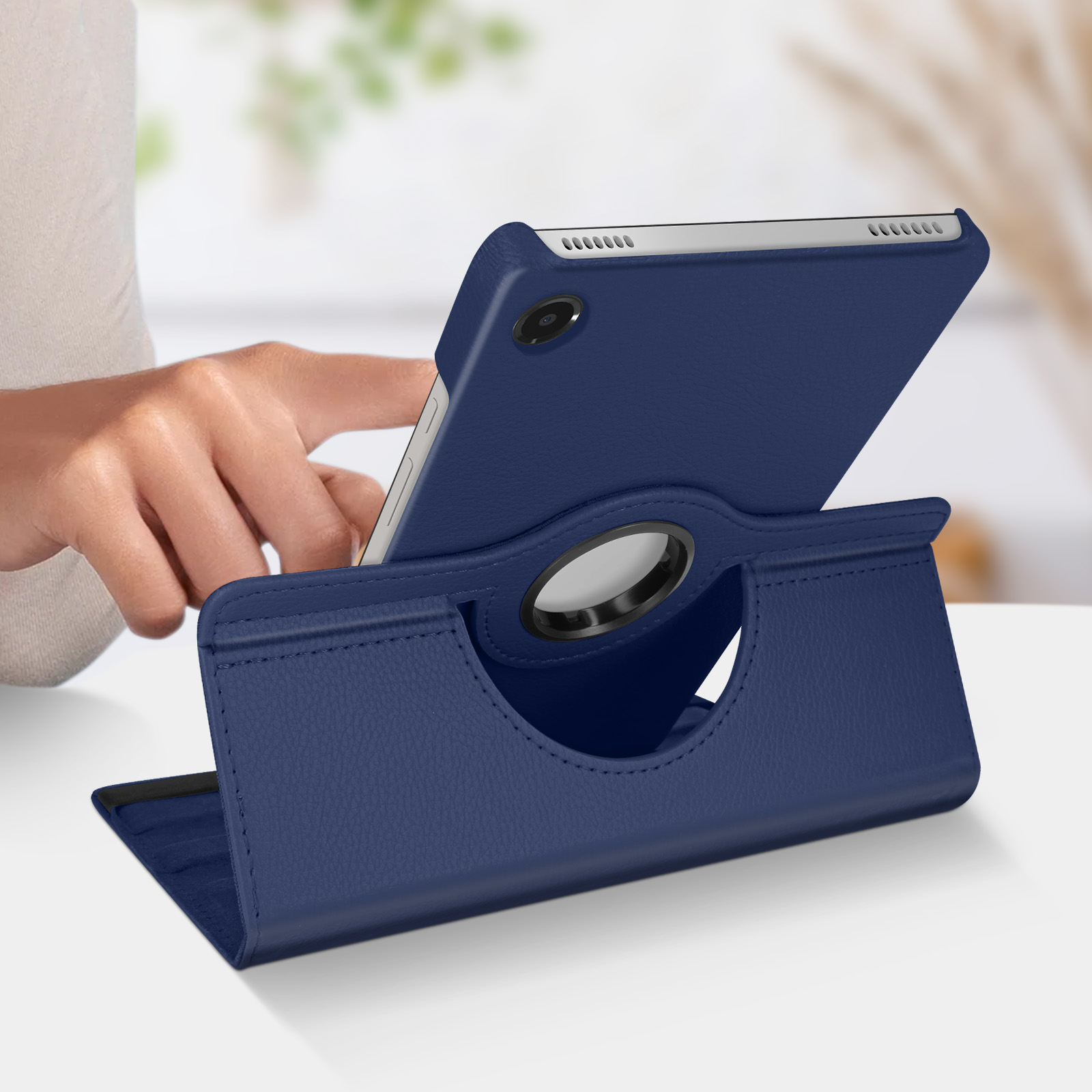 Un tablet blu navy in una custodia con supporto rotante. Una mano posiziona il tablet.