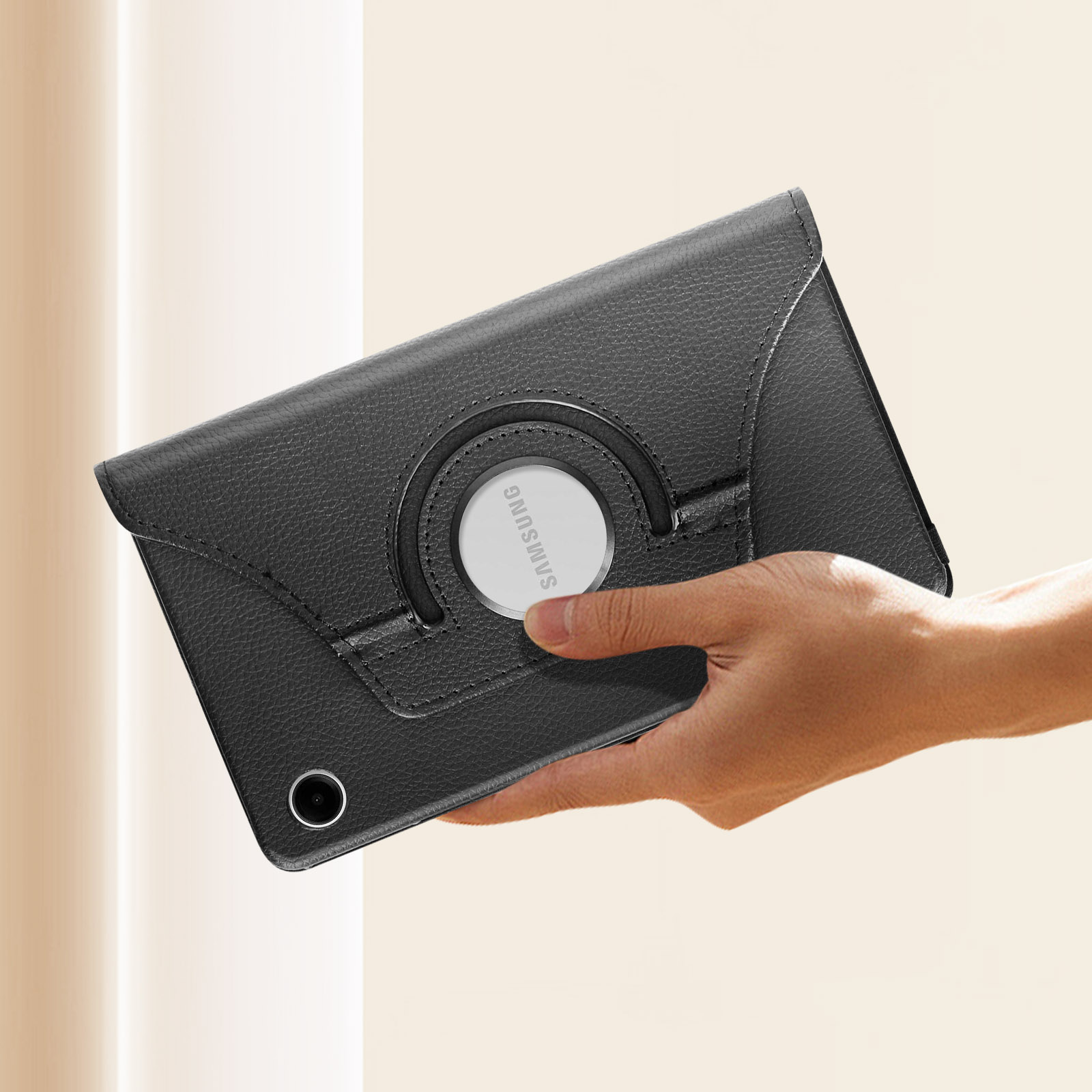Tablet nero in una custodia, tenuto in mano. La custodia ha un anello girevole al centro.