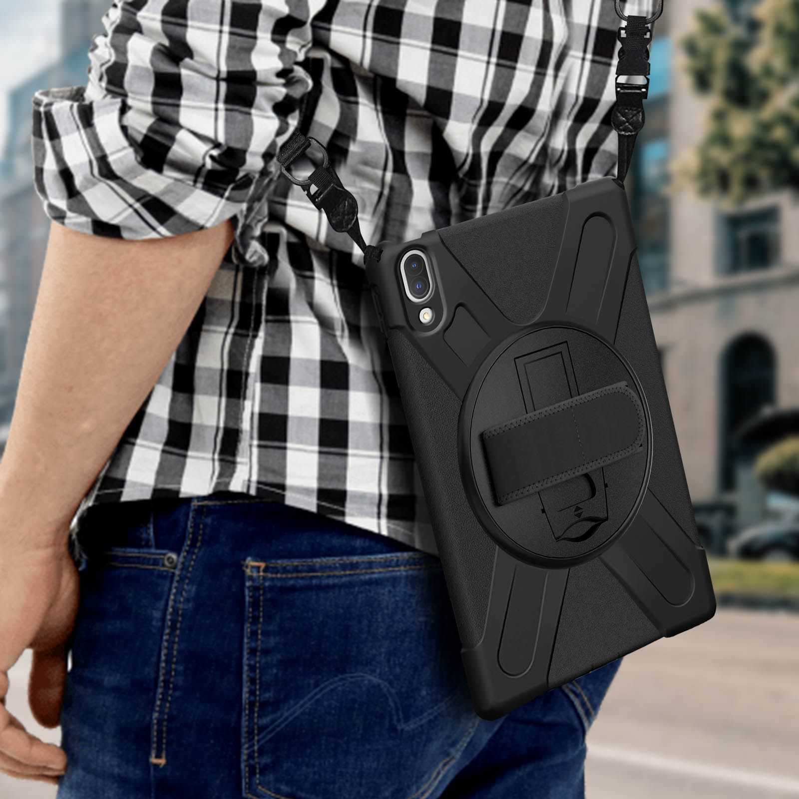 Una persona con jeans e camicia a quadri, ha una custodia nera per tablet con cinturino.