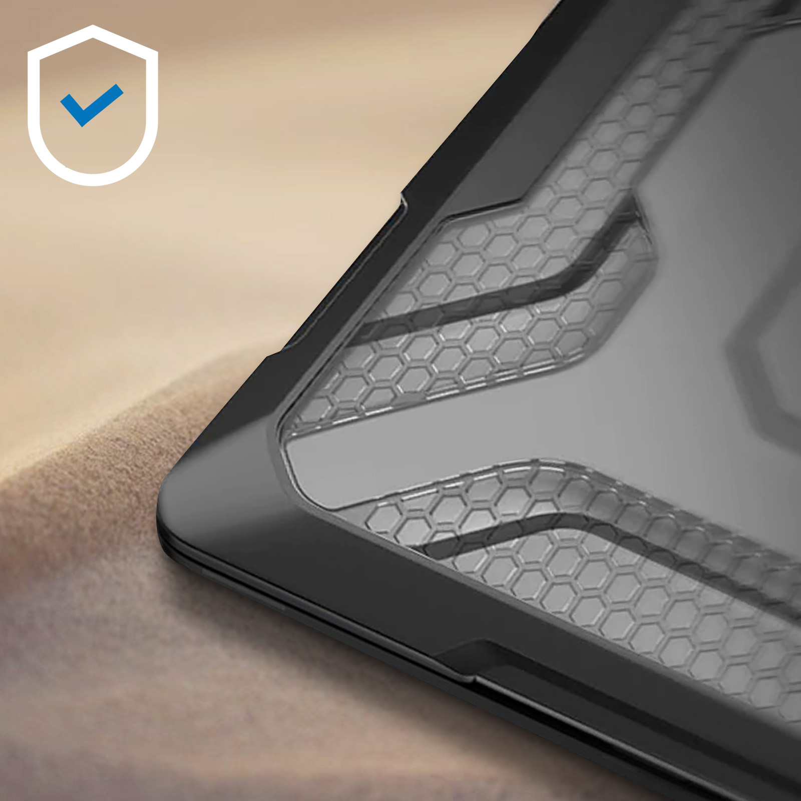 Primo piano di una custodia per laptop nera. Lo sfondo è sabbia.