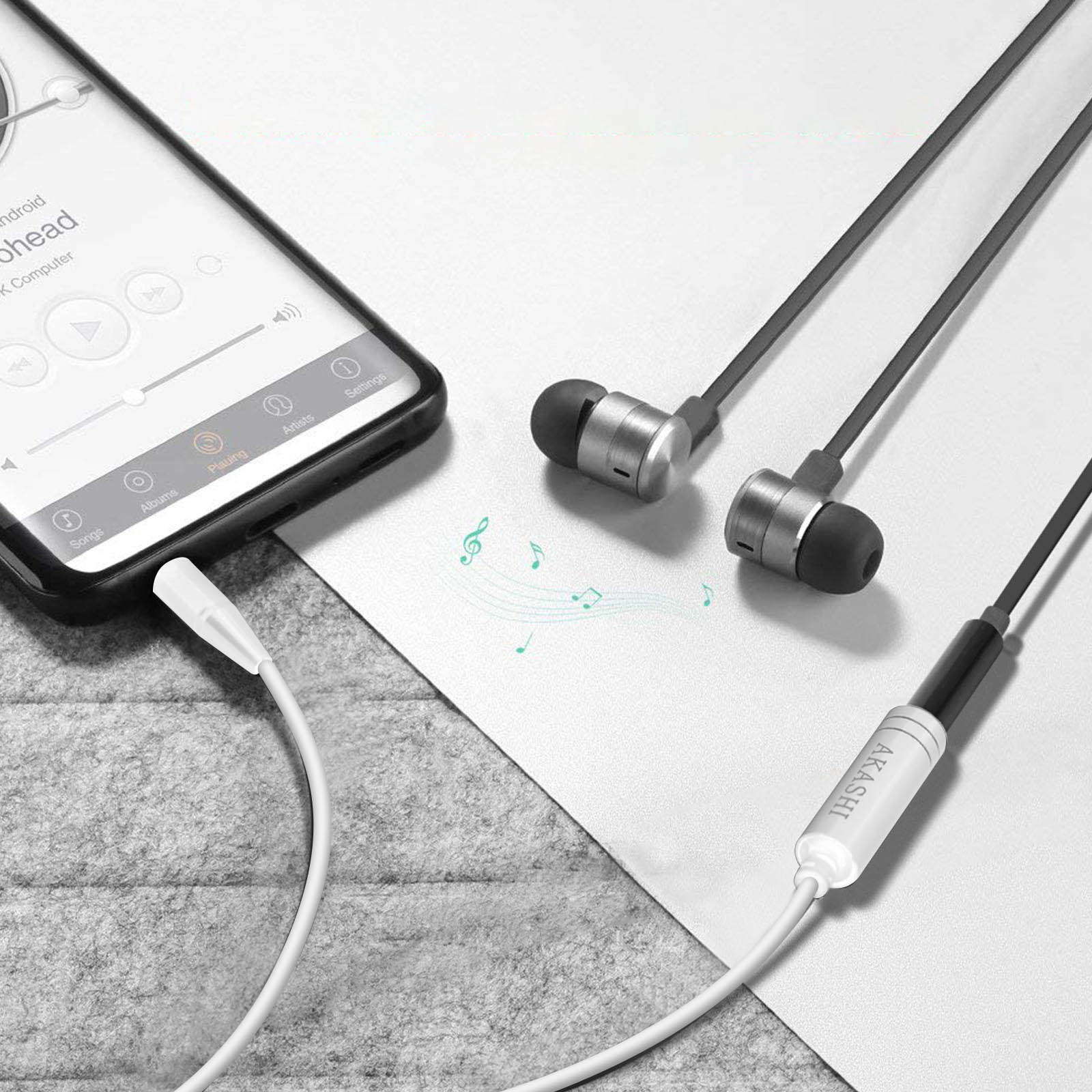 Auricolari collegati al telefono che riproduce musica. Auricolari argento e neri.