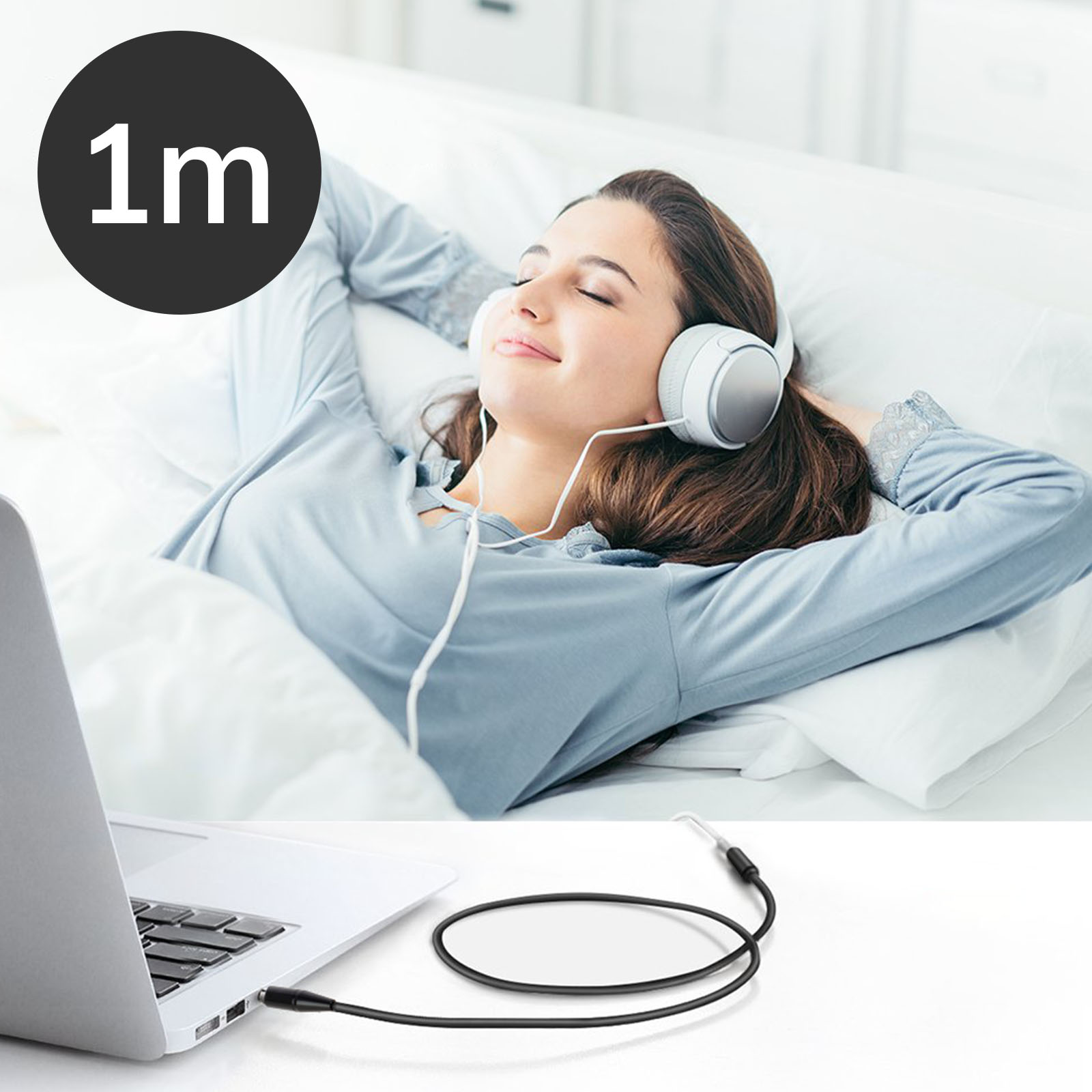 Una donna a letto con le cuffie, collegata a un laptop con un cavo da 1 m.