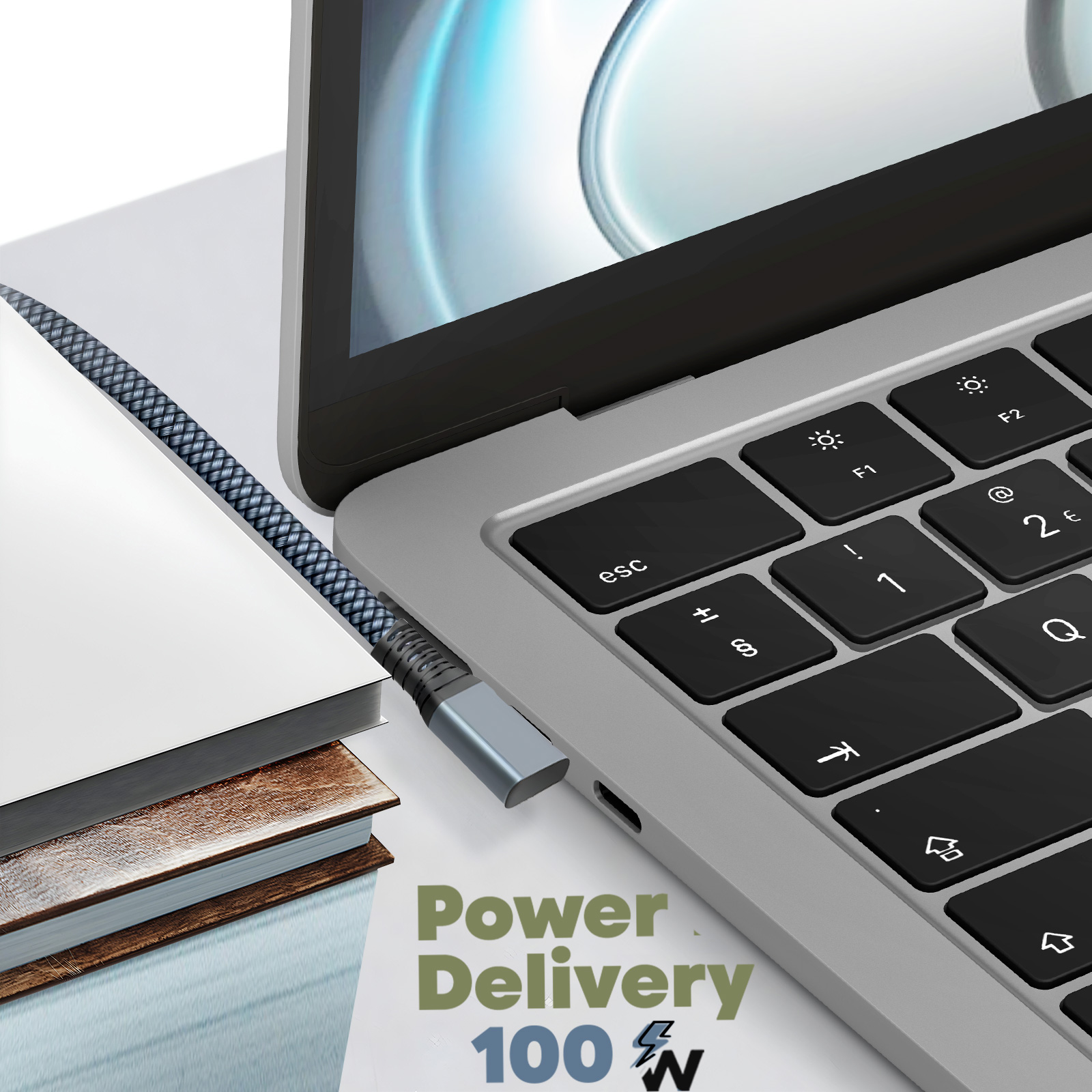Laptop con cavo di ricarica collegato. Testo del cavo: Power Delivery 100 W. Libro.