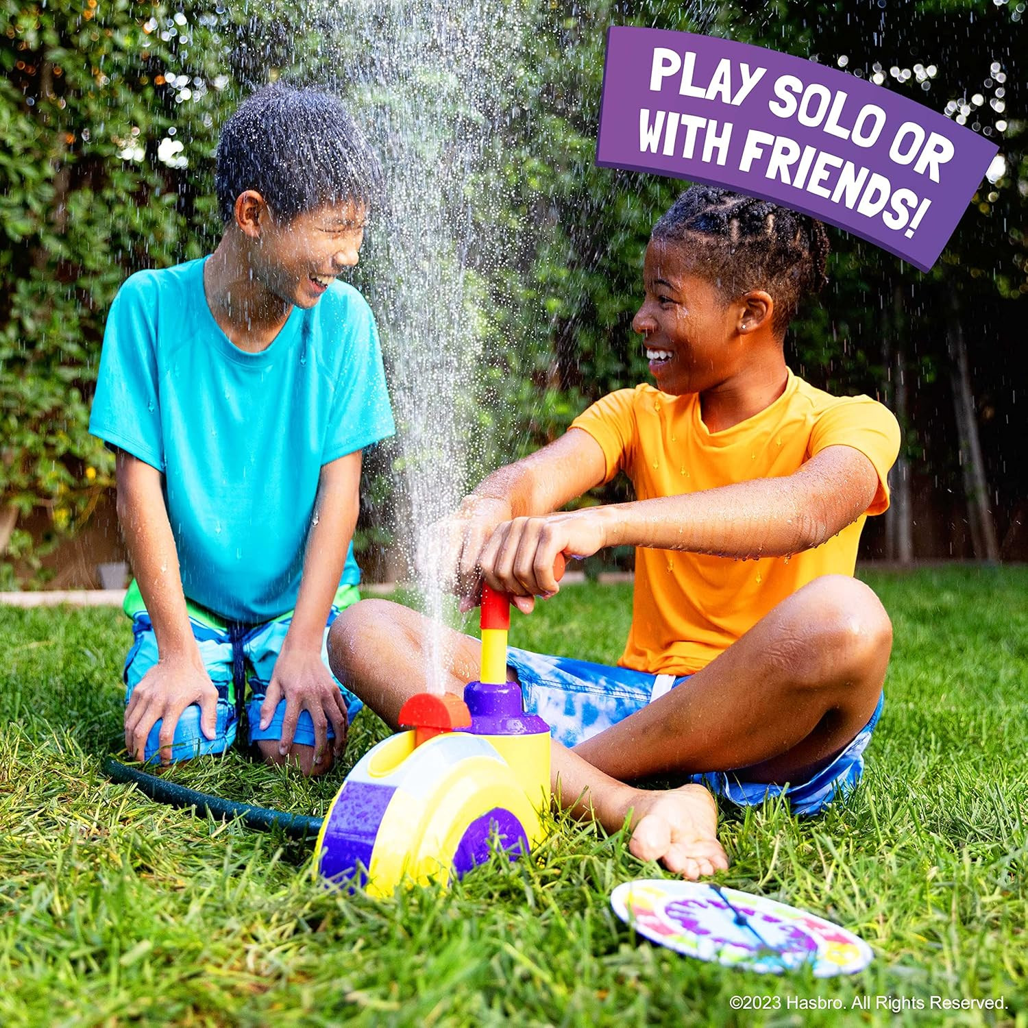 Zwei lächelnde Kinder spielen mit einem Wasserspielzeug, Wasser spritzt und ein farbenfrohes Spiel.