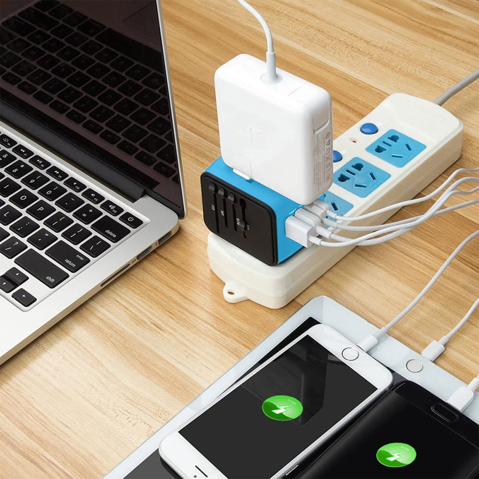 Geräte laden: Laptop, Tablet und zwei Telefone. Steckdosenleiste mit mehreren Steckern und Reiseadapter.