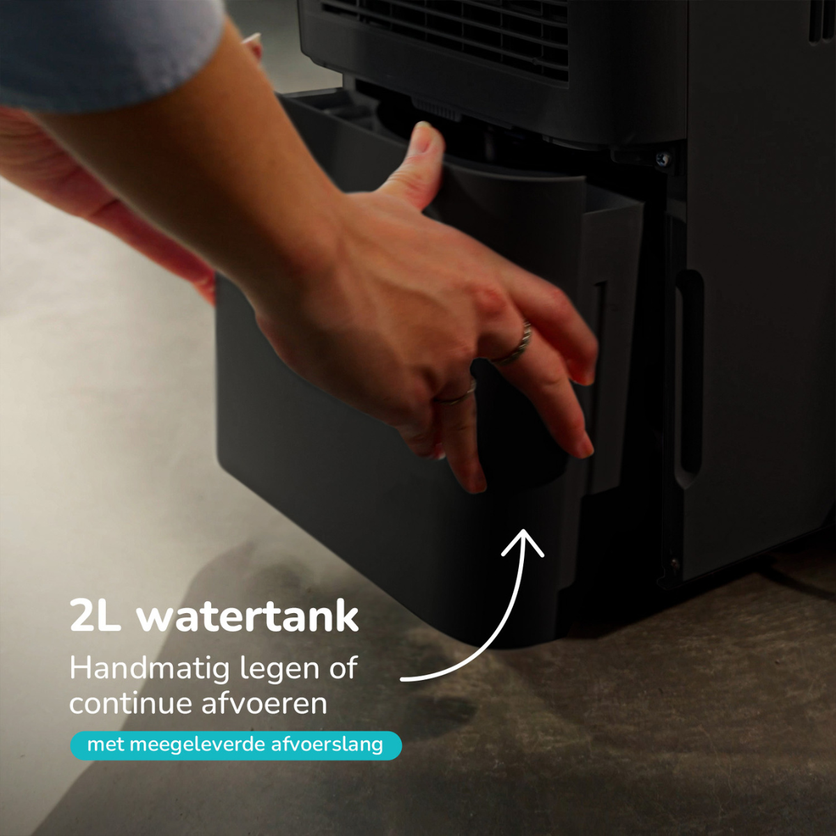 Hand einer Frau, die einen schwarzen Wassertank aus einem schwarzen Gerät entfernt.