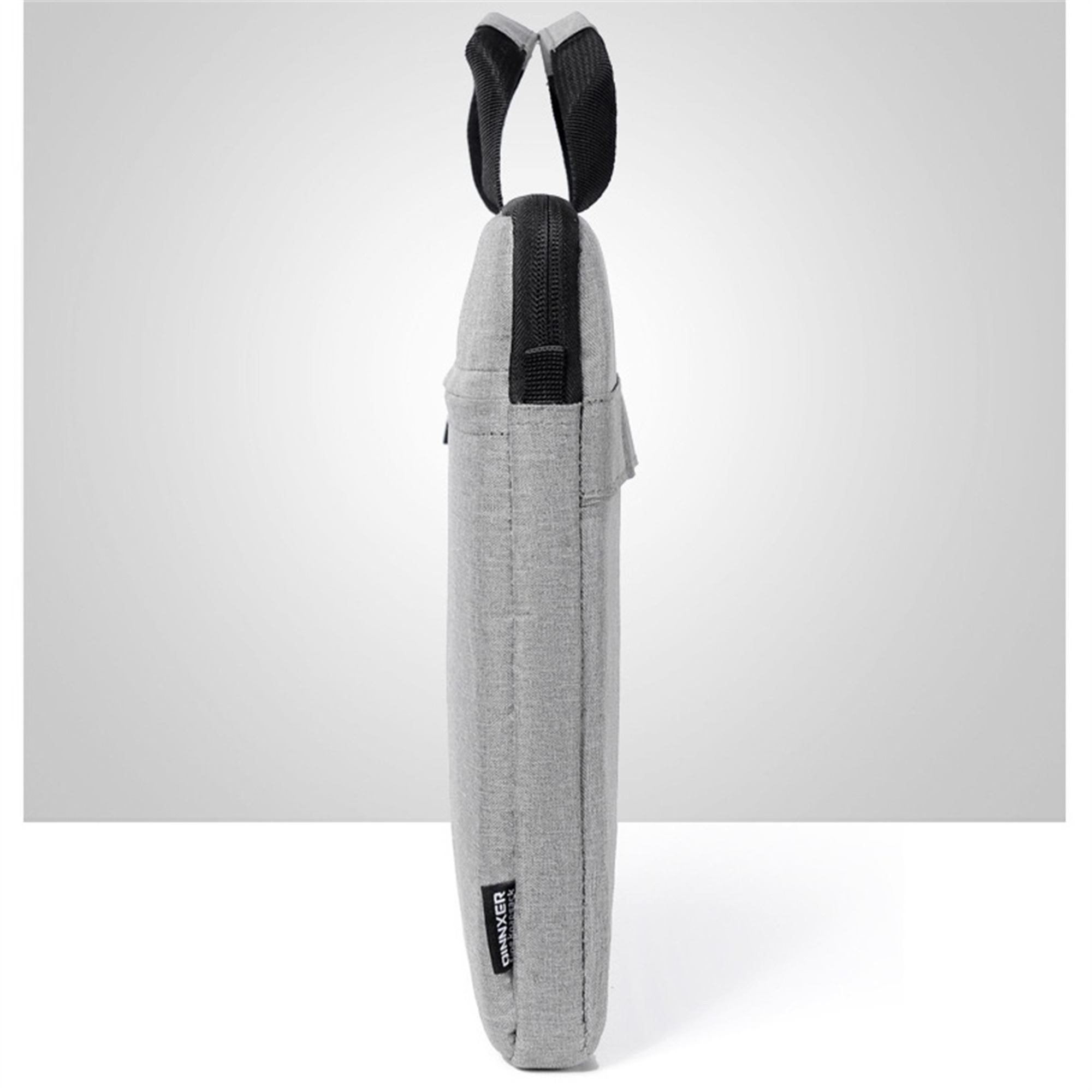 Graue Laptoptasche mit schwarzem Griff und Reißverschluss, ein Etikett mit Text ist sichtbar.