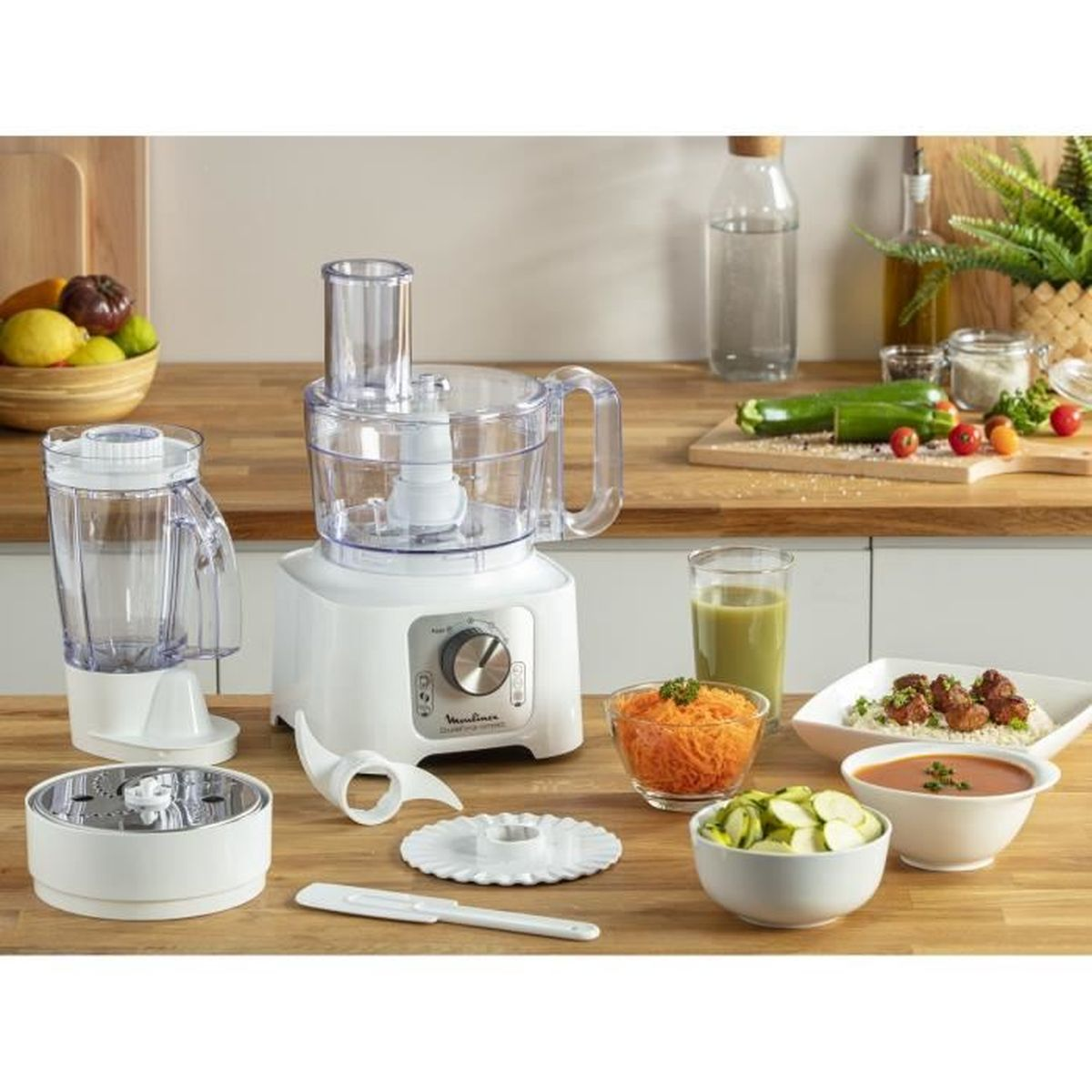 Un robot da cucina bianco con accessori e ingredienti su un piano di lavoro in legno.