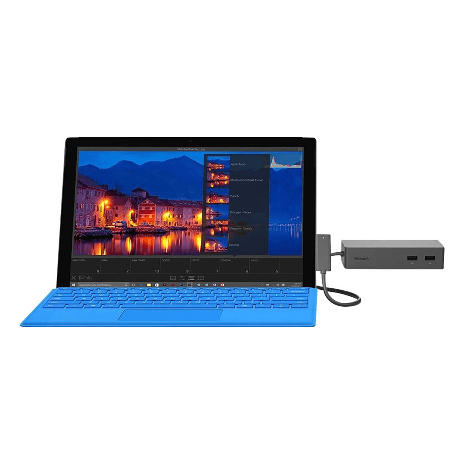 Ein Laptop mit blauer Tastatur, verbunden mit einem Hub und einem grauen Gerät. Der Bildschirm zeigt einen Fotoeditor.