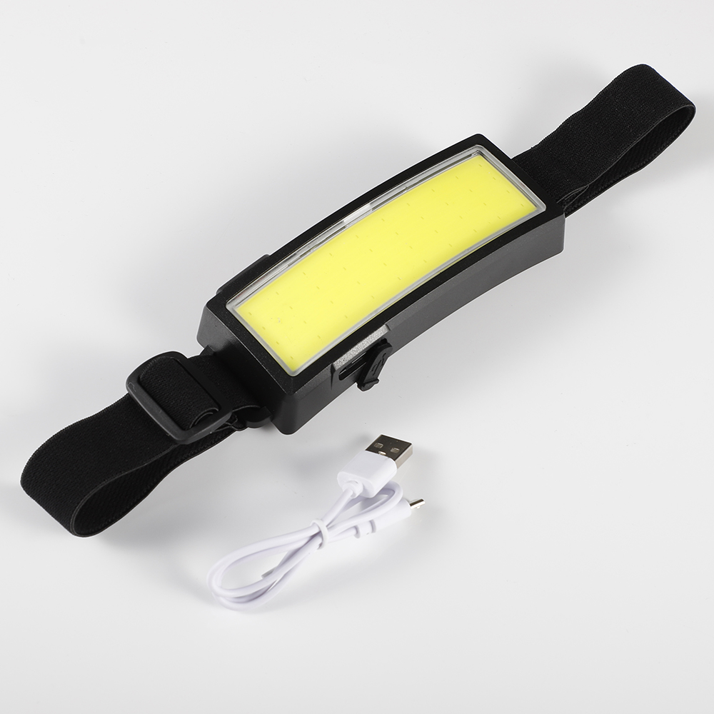 Schwarze Stirnlampe mit weißem Lichtbalken und USB-Ladekabel. Sie hat einen verstellbaren Riemen.