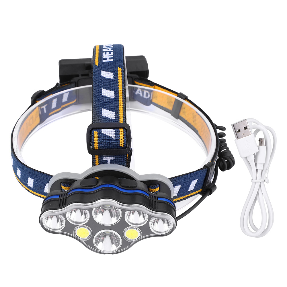 Stirnlampe mit mehreren Lichtern und blauem Band. Ein weißes Kabel und Stecker daneben.