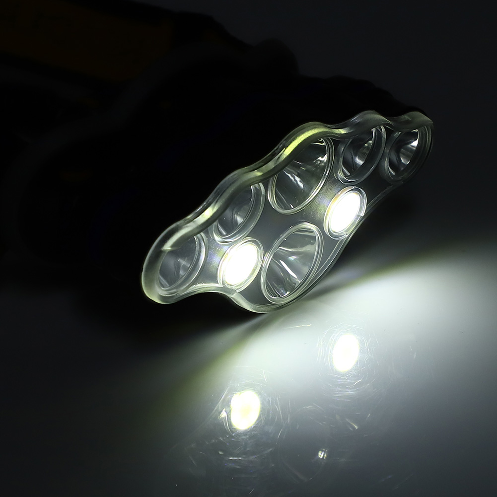 Transparente LED-Leuchte mit mehreren Lichtern, die sich auf einer weißen Oberfläche spiegeln. Dunkler Hintergrund.