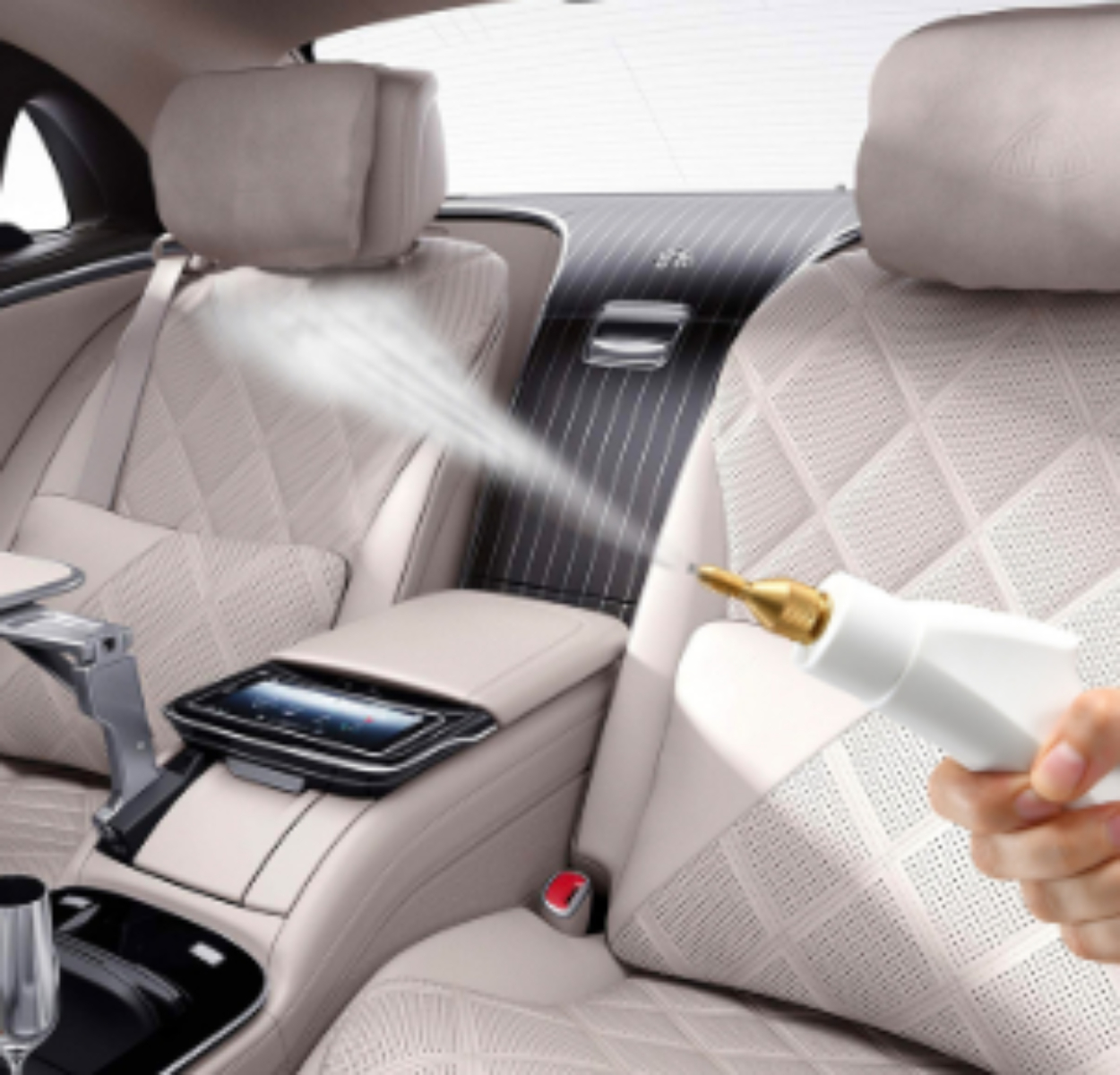 Eine Person sprüht ein weißes Reinigungsmittel in einen Autoinnenraum. Beige Sitze und Armaturenbrett.