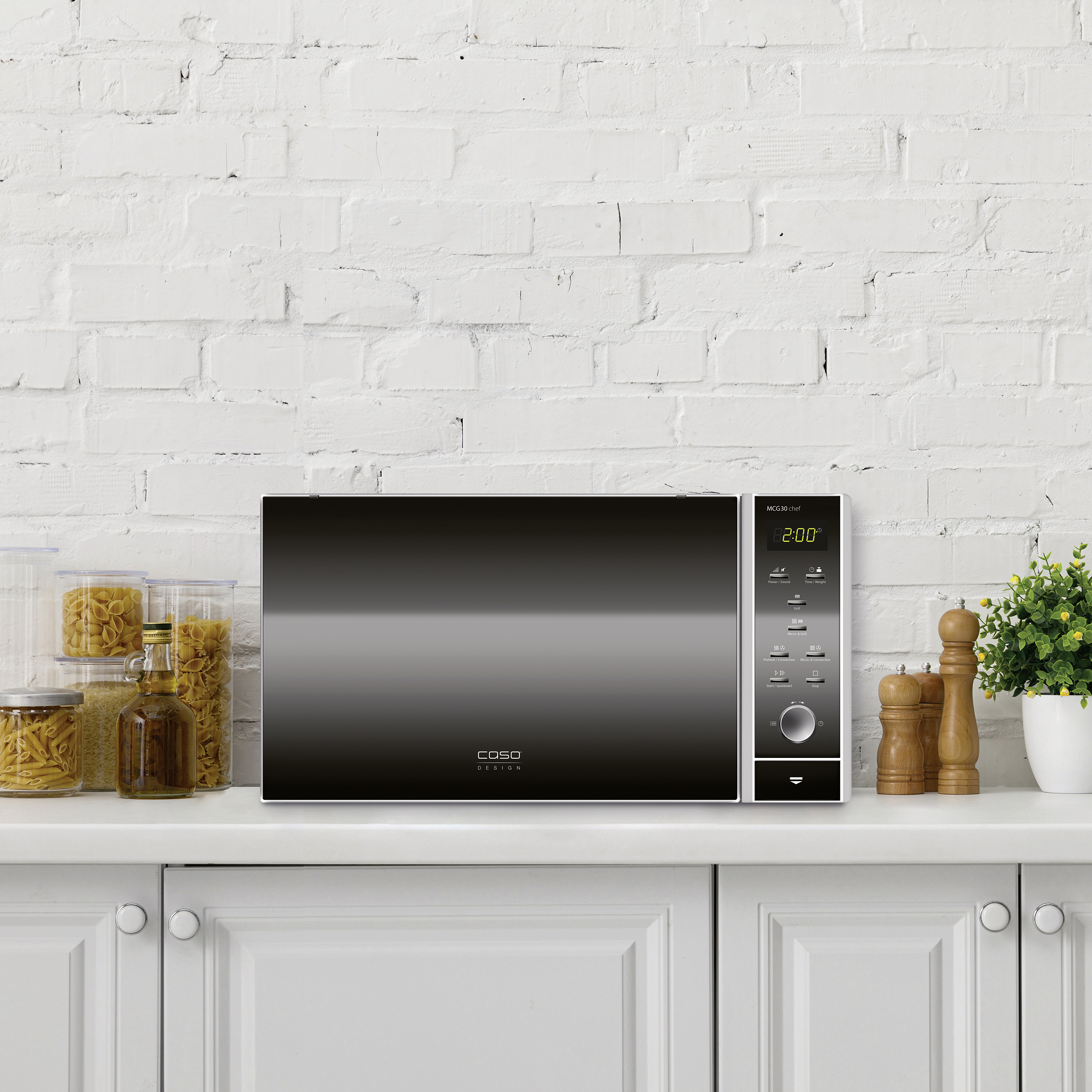 Un forno a microonde nero su un bancone bianco con oggetti da cucina.