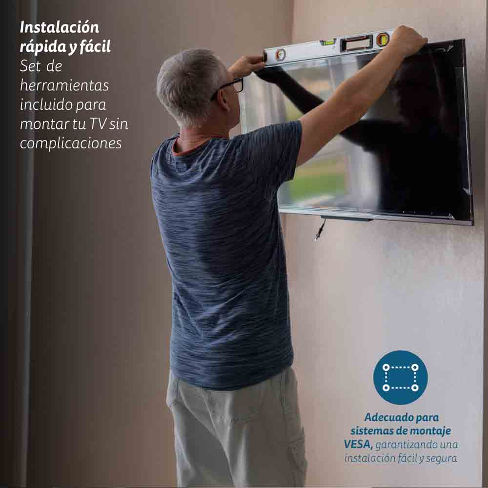 Un hombre instalando un televisor en una pared, usando un nivel. Se ve texto en español.
