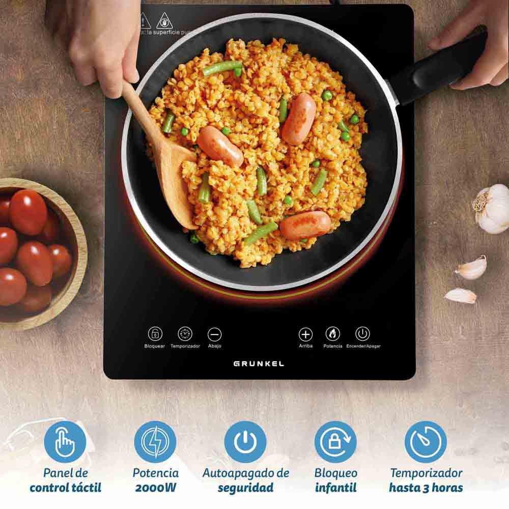 Un piano cottura nero con cibo. I controlli includono blocco, timer, alimentazione e pannello tattile.