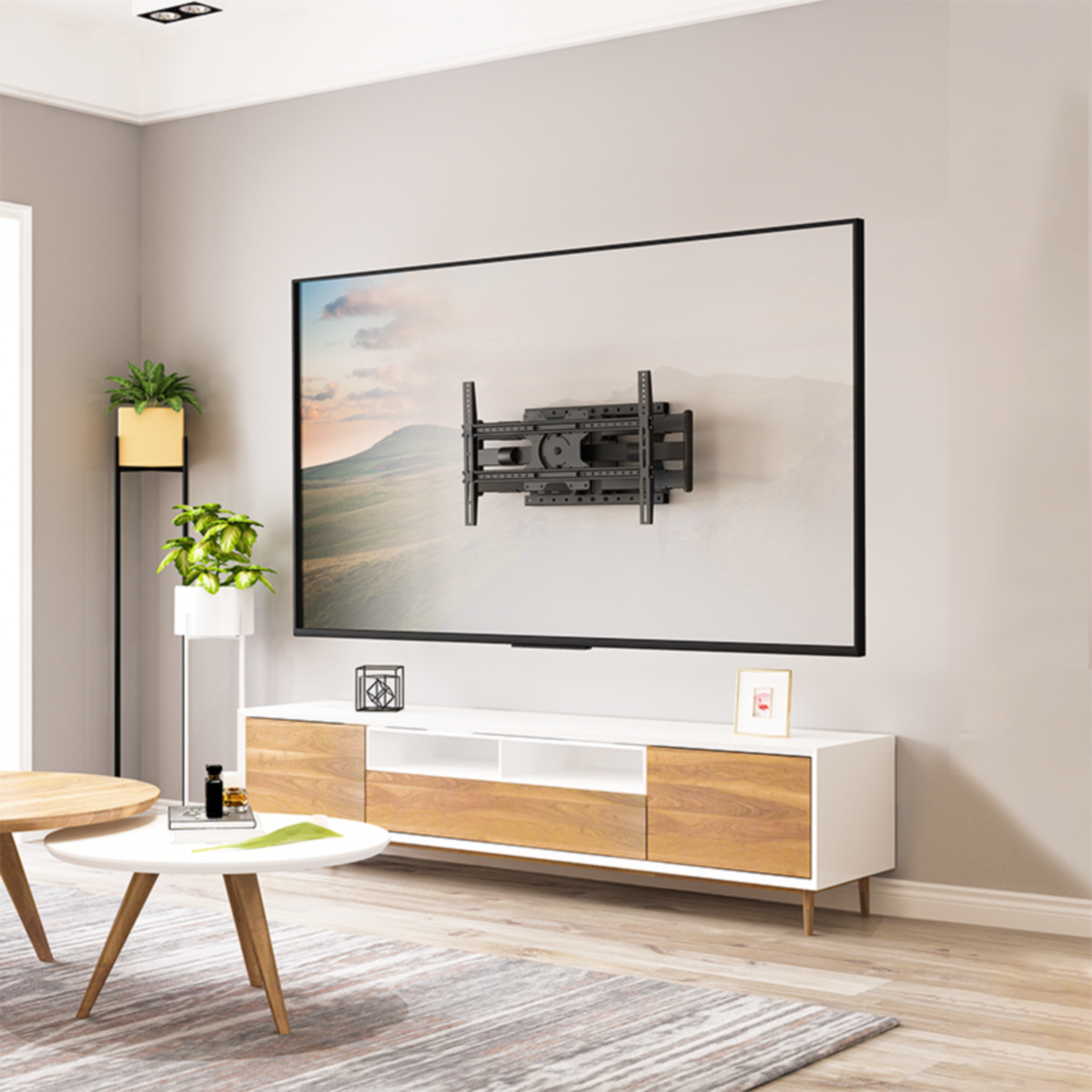 Woonkamer met tv aan de muur, witte tafel en plant.