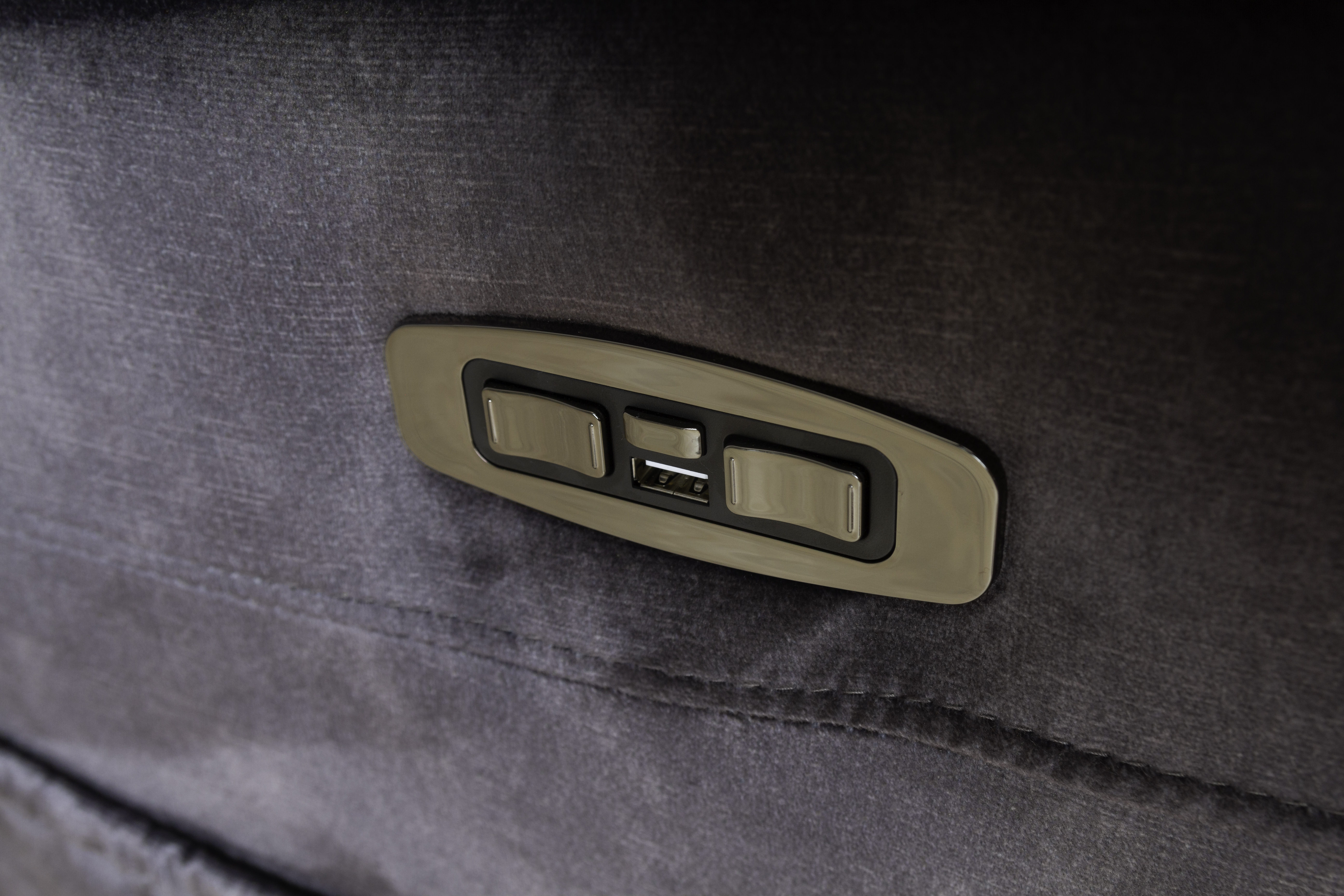 Primer plano de un panel de control de muebles con botones y puertos USB.