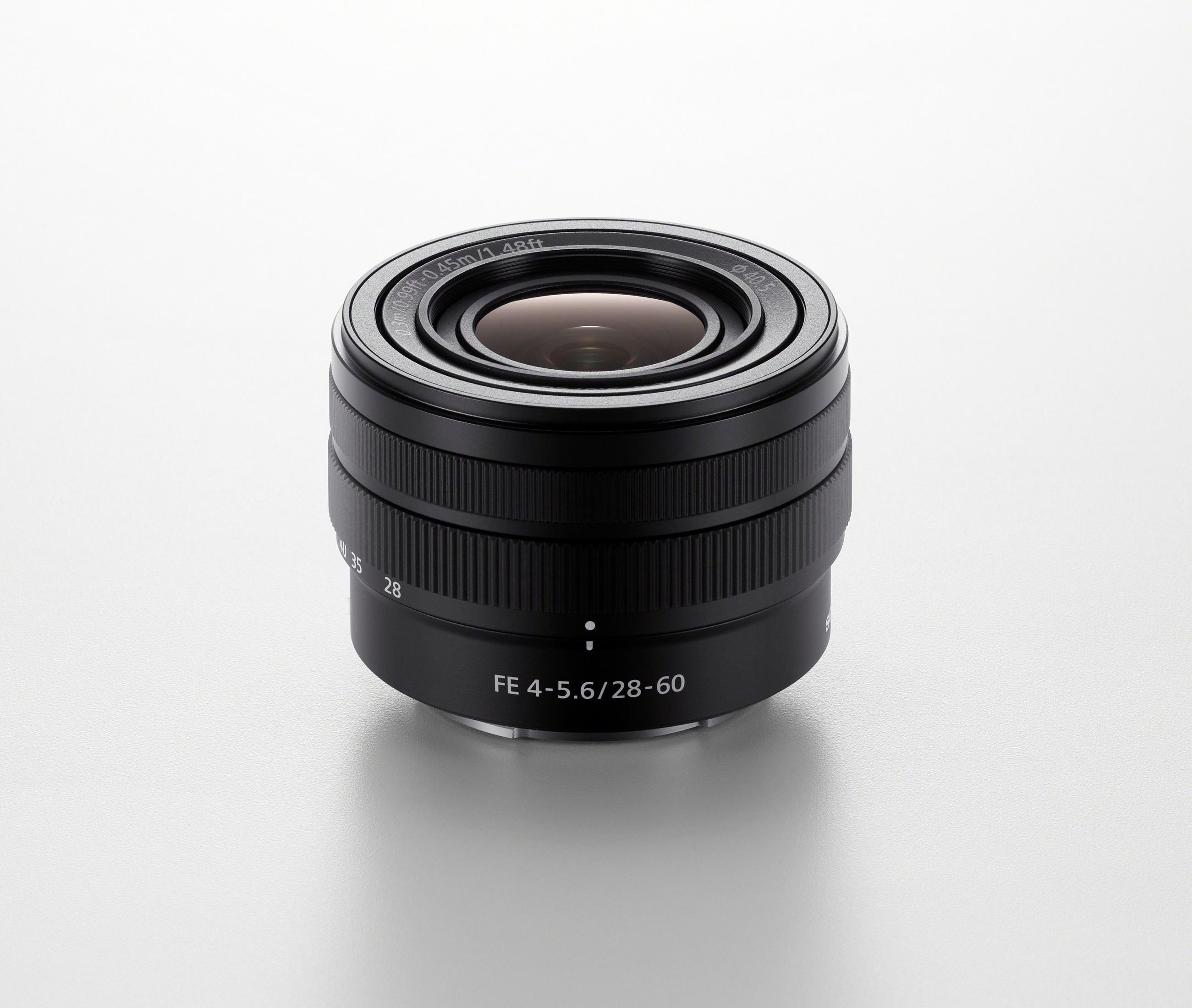 Czarny obiektyw na białej powierzchni. Obiektyw ma oznaczenia. Mała głębia ostrości.