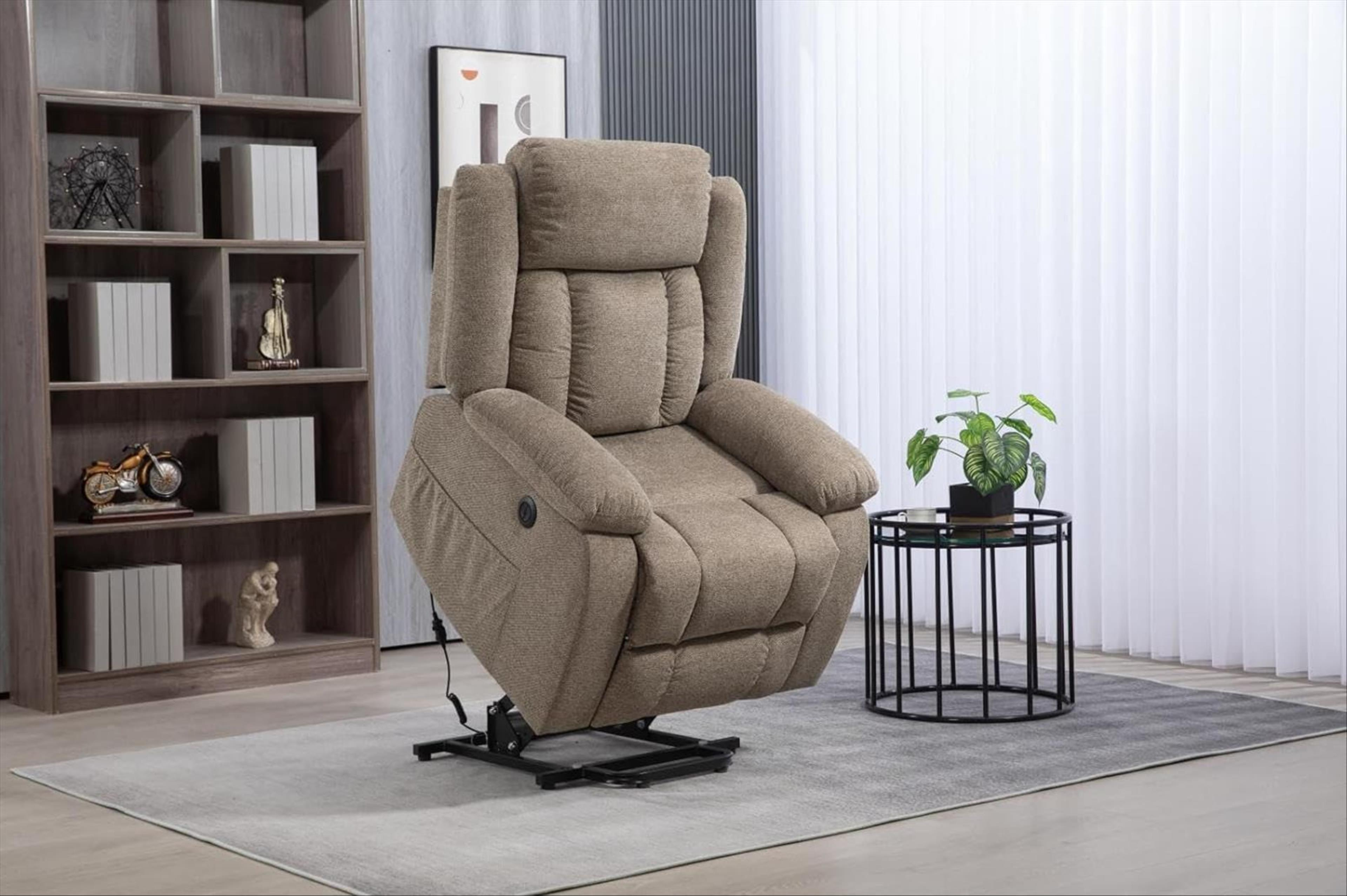 Sillón reclinable beige con una planta en una mesa auxiliar junto a una estantería.