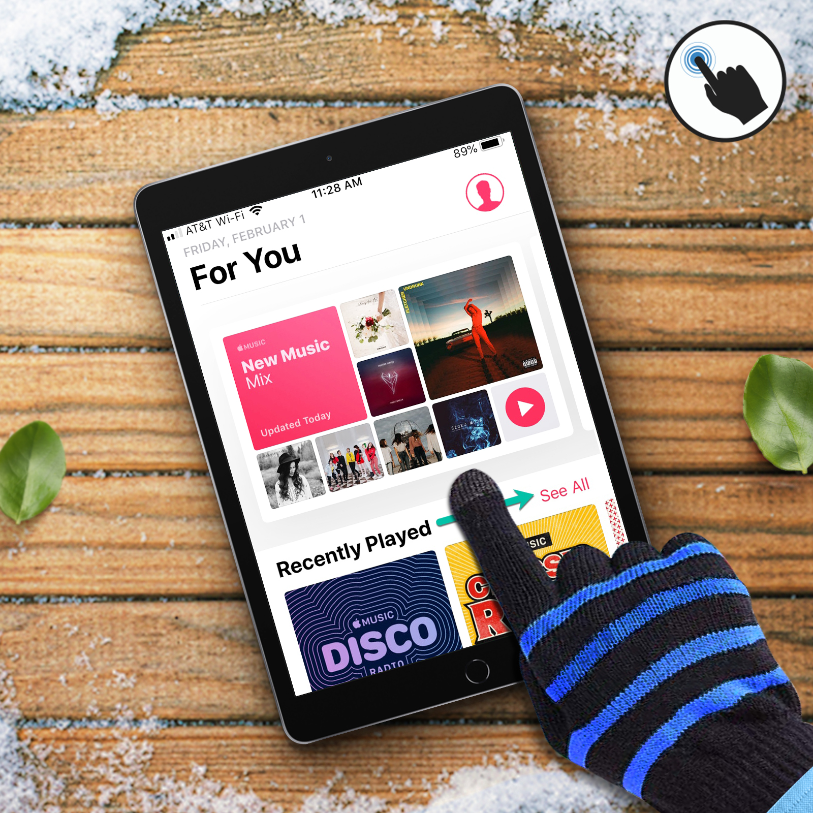 Schermo iPad che mostra l'interfaccia di un'app musicale. Una mano guantata tocca lo schermo. Superficie in legno innevata sullo sfondo.