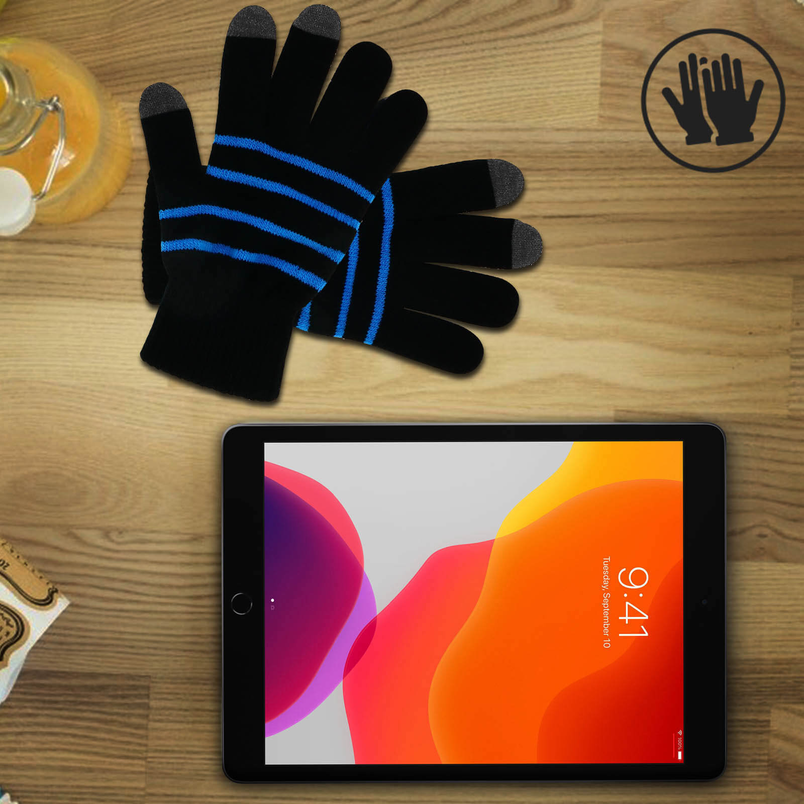 Guanti neri touchscreen e un tablet. Il tablet mostra una grafica colorata, icona mani.