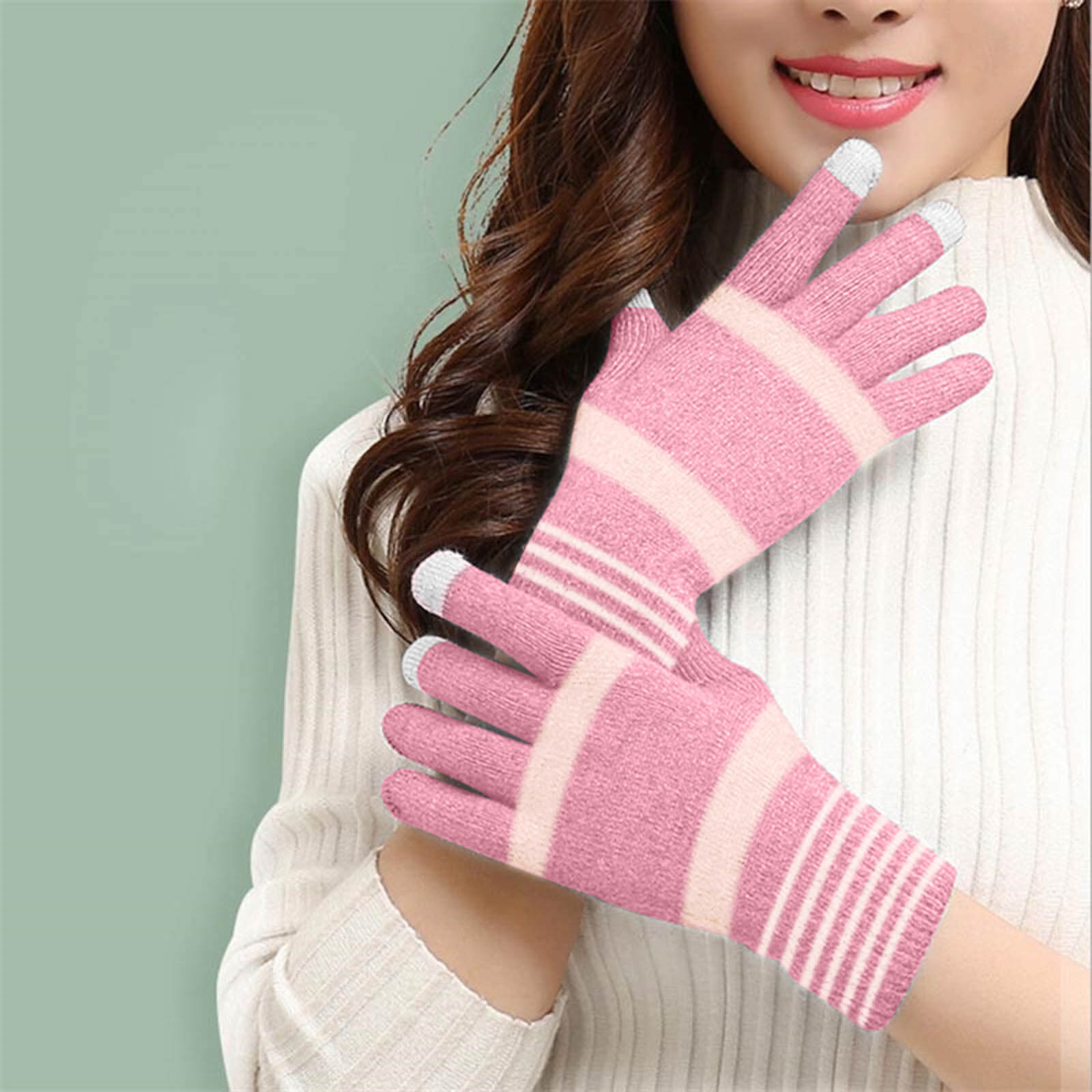 Femme portant des gants rayés roses et blancs avec des bouts des doigts blancs. Elle sourit.