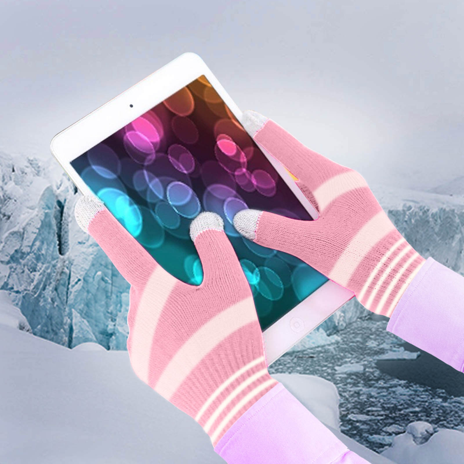 Gants roses à rayures blanches tenant une tablette, avec un paysage enneigé en arrière-plan.