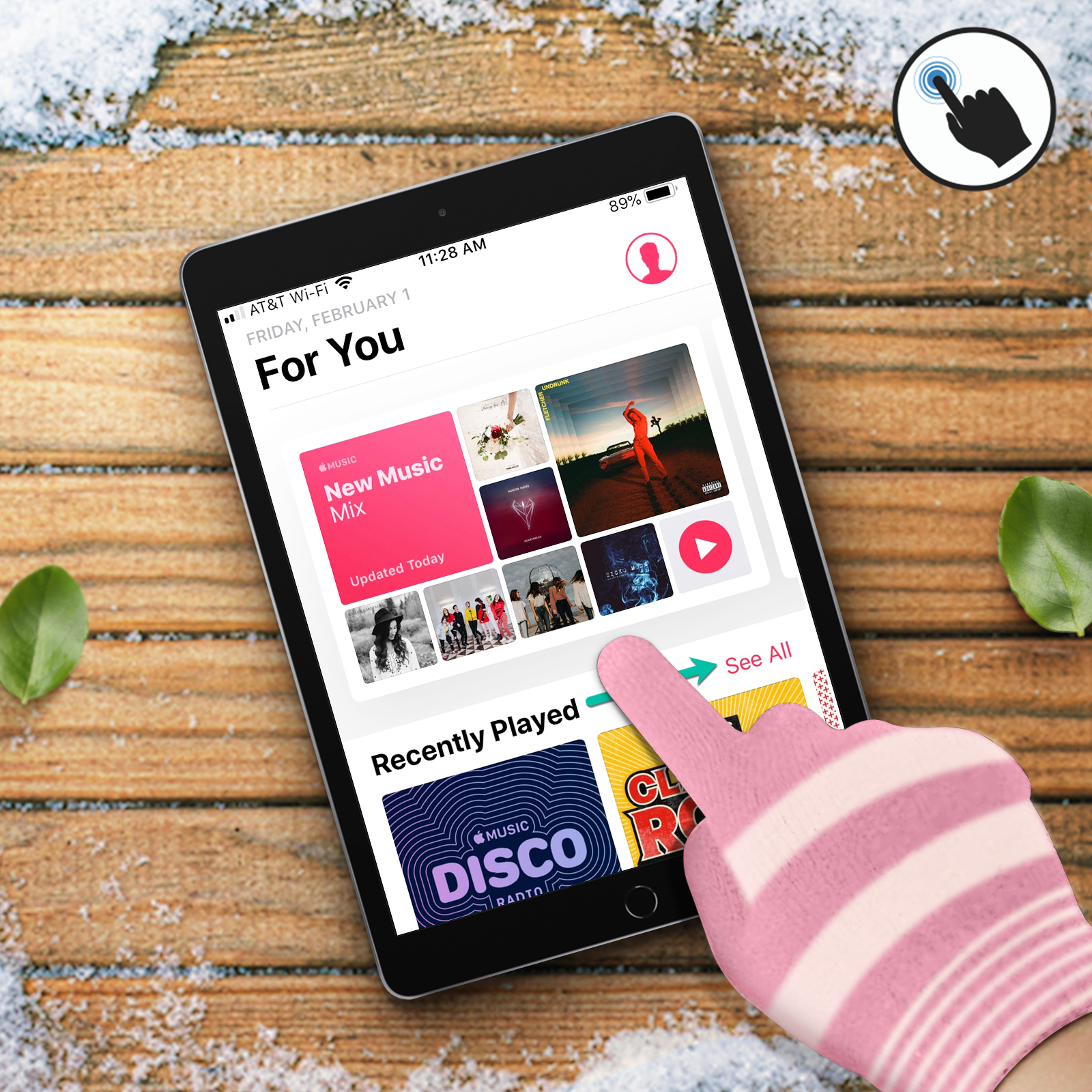 Un iPad affiche une application de musique. Une main gantée de rose et blanc rayé touche l'écran.