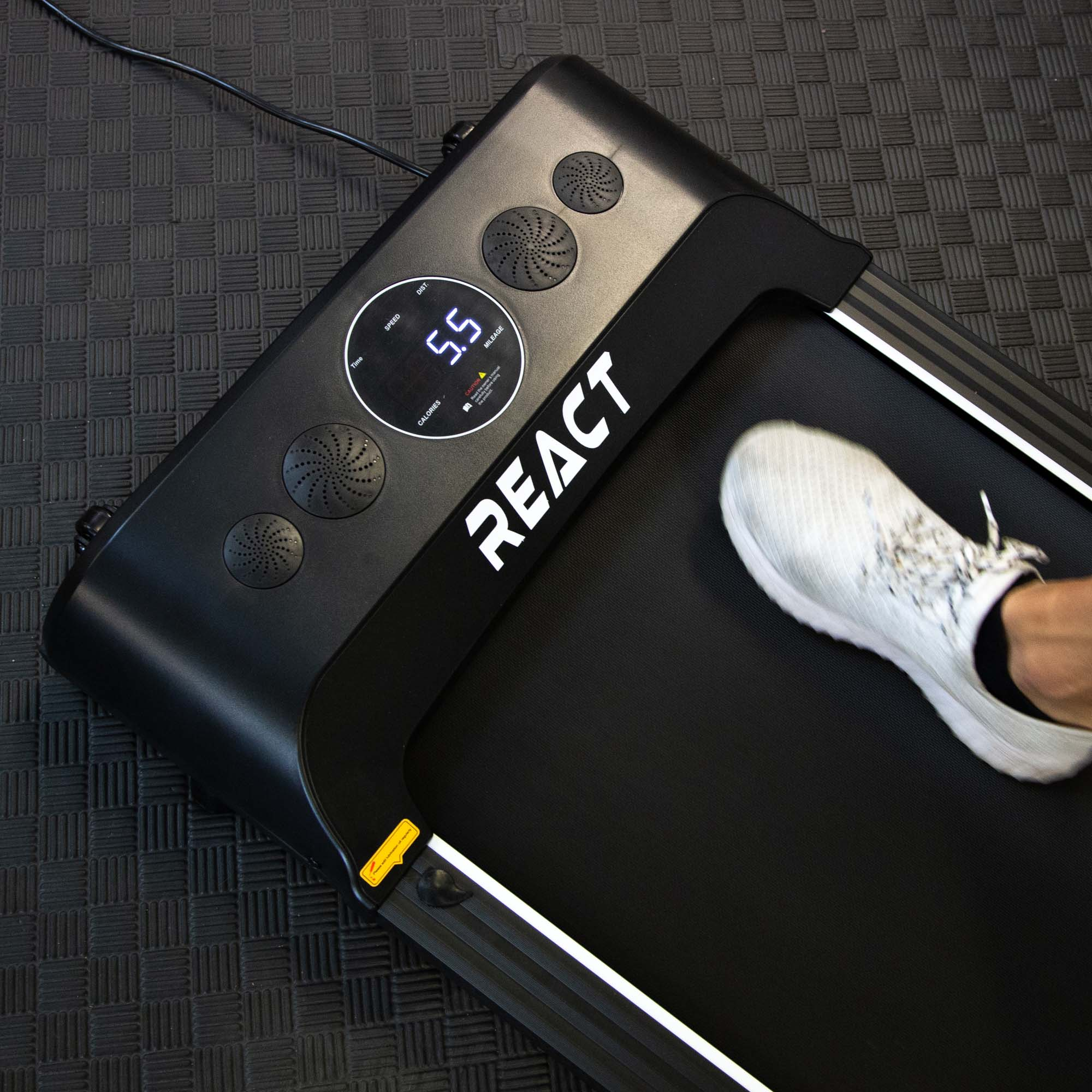 Stopa osoby na bieżni, z wyświetlaczem pokazującym prędkość i kalorie.