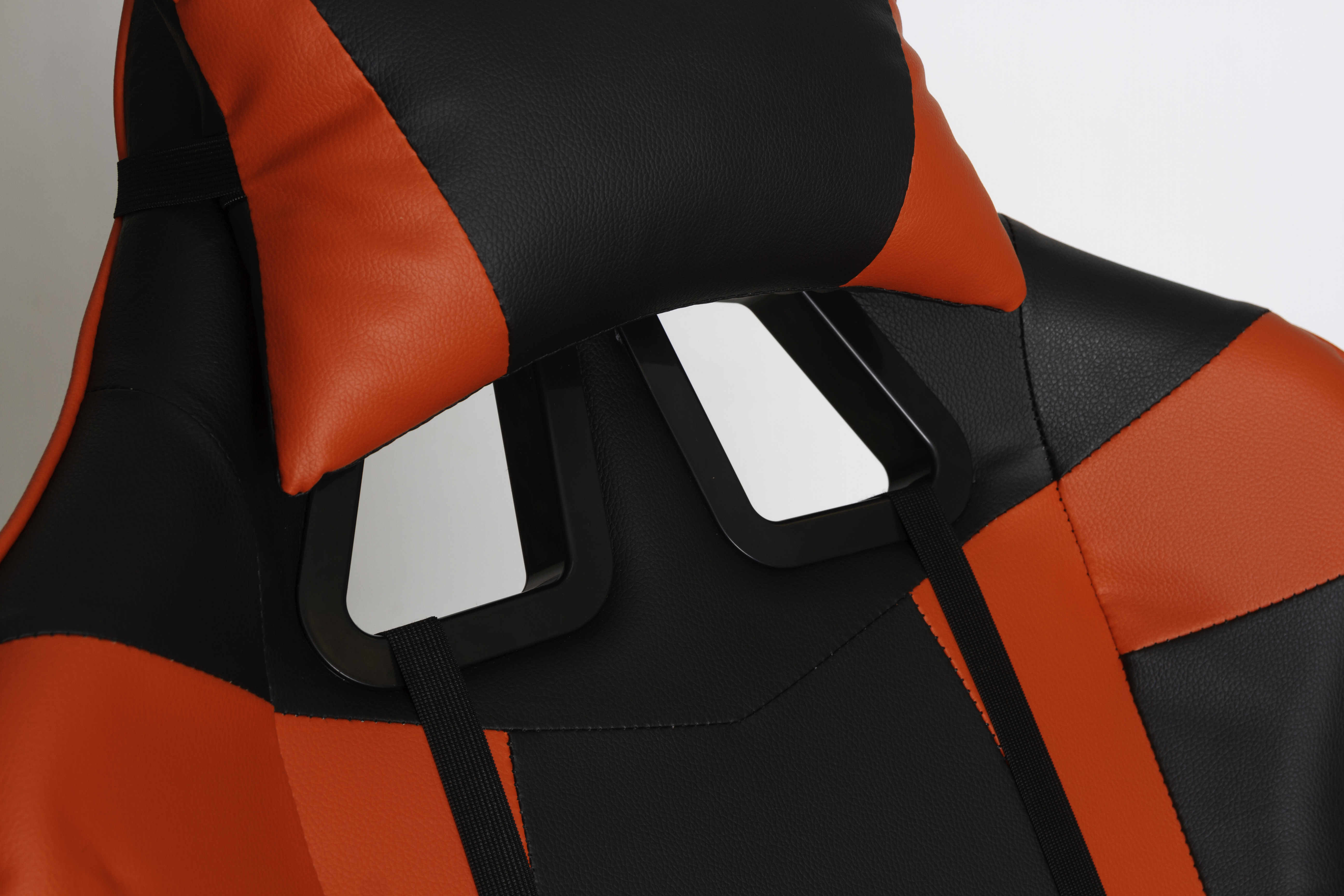Primer plano de una silla gamer roja y negra. El reposacabezas tiene un panel blanco.