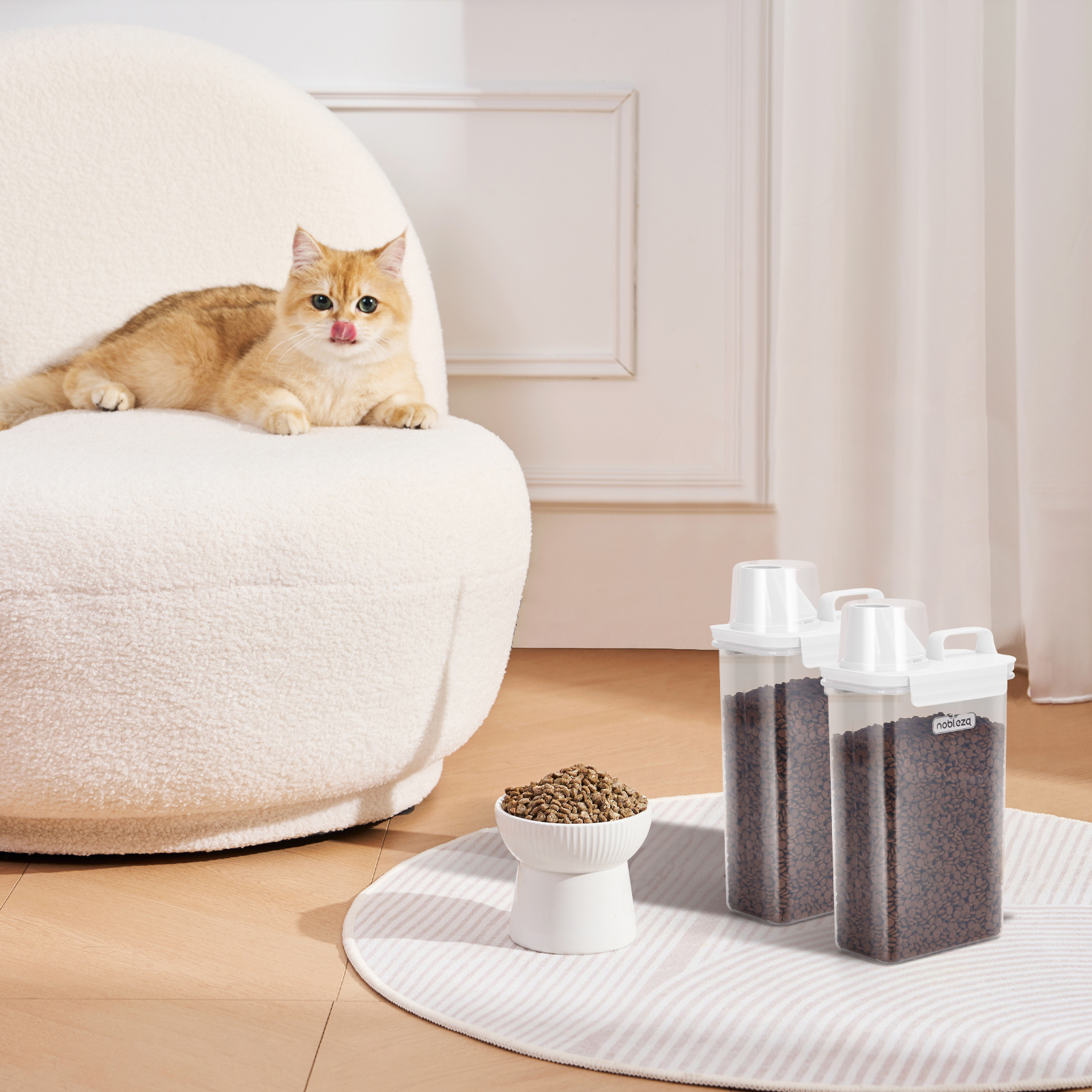 Un gato en una silla, dos recipientes para comida de mascotas y un cuenco de pienso sobre una alfombra.