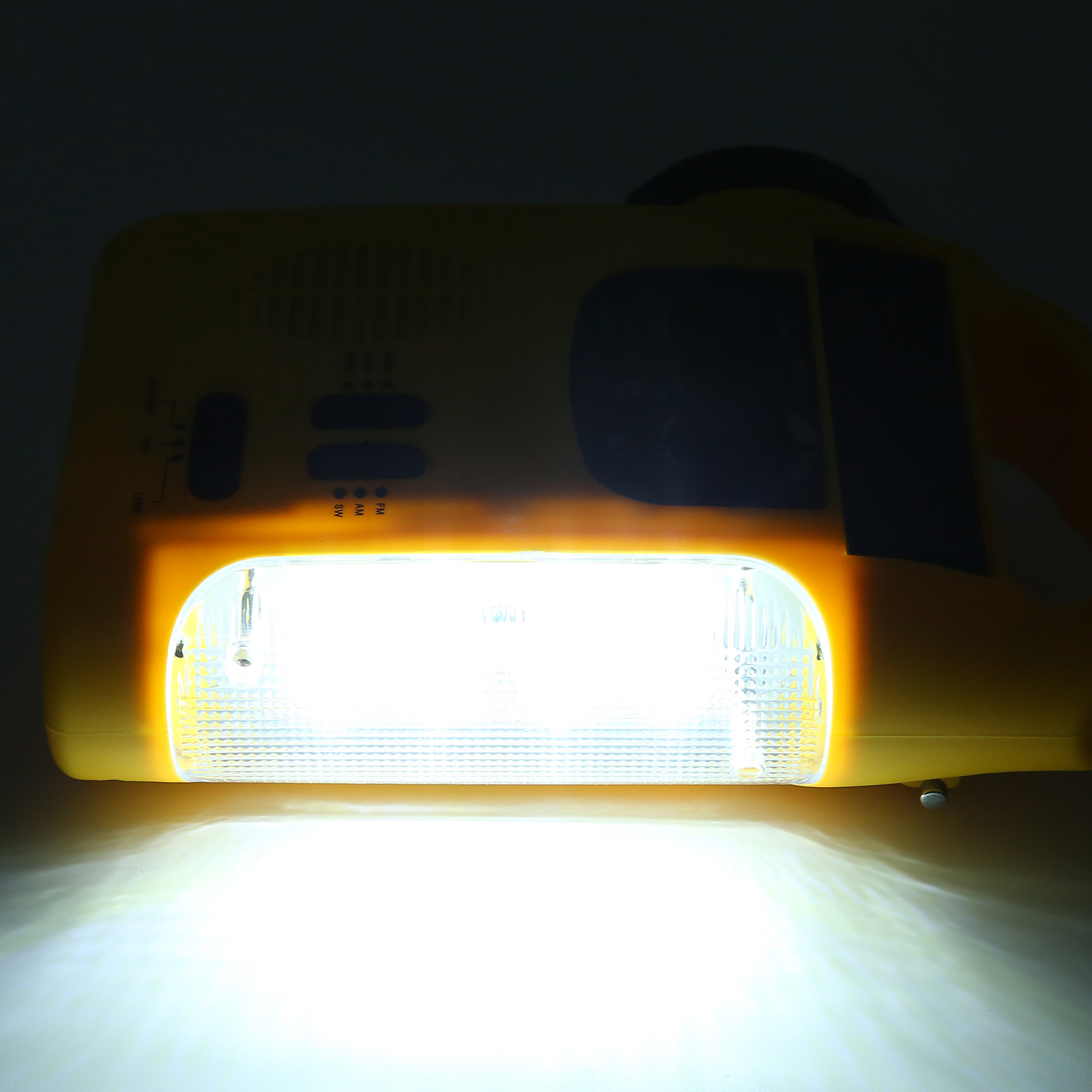 Gelbe Taschenlampe mit hellem weißen Licht, das von vorne ausgeht.