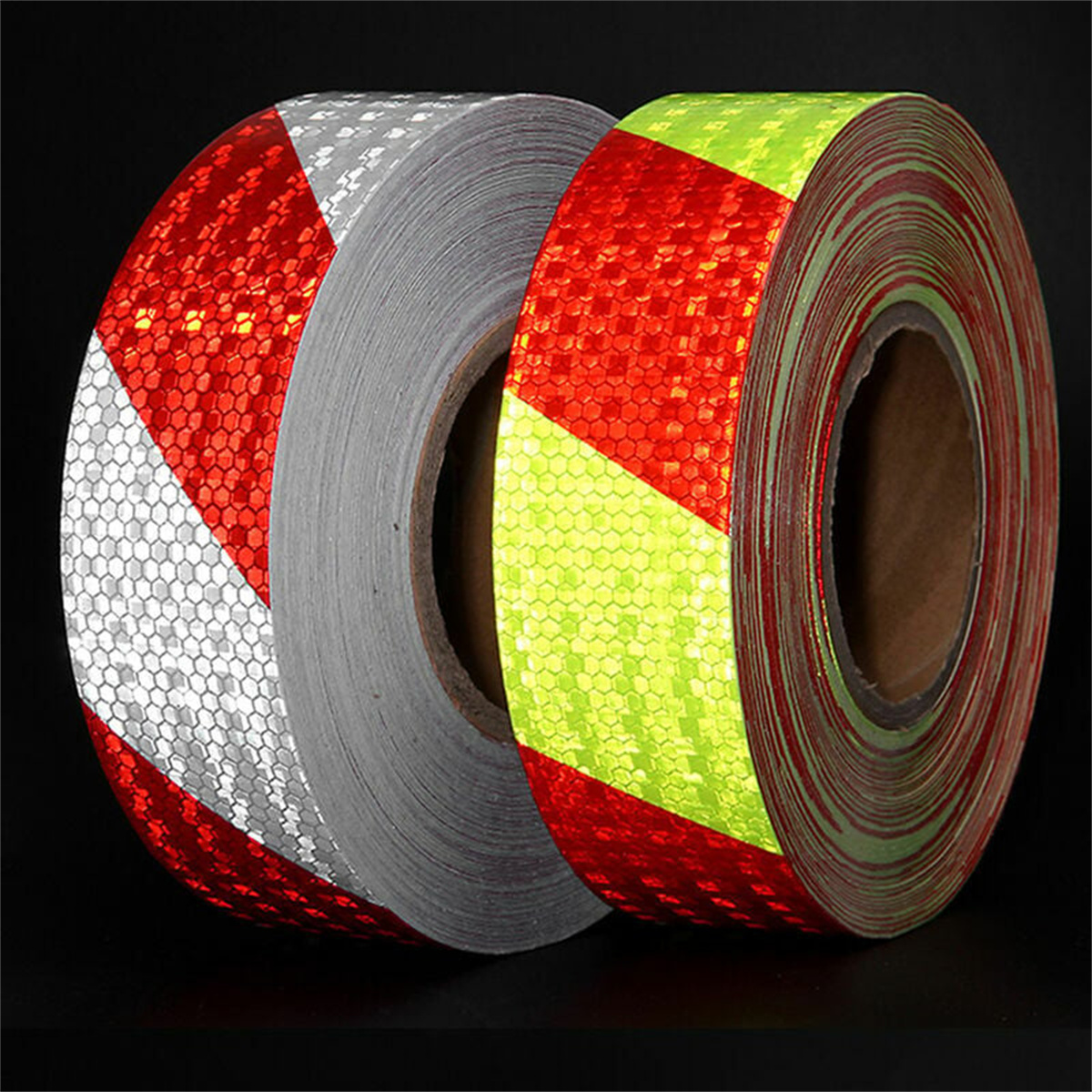 Zwei Rollen reflektierendes Klebeband, rot und silber. Das Band hat ein Wabenmuster mit diagonalen Streifen.